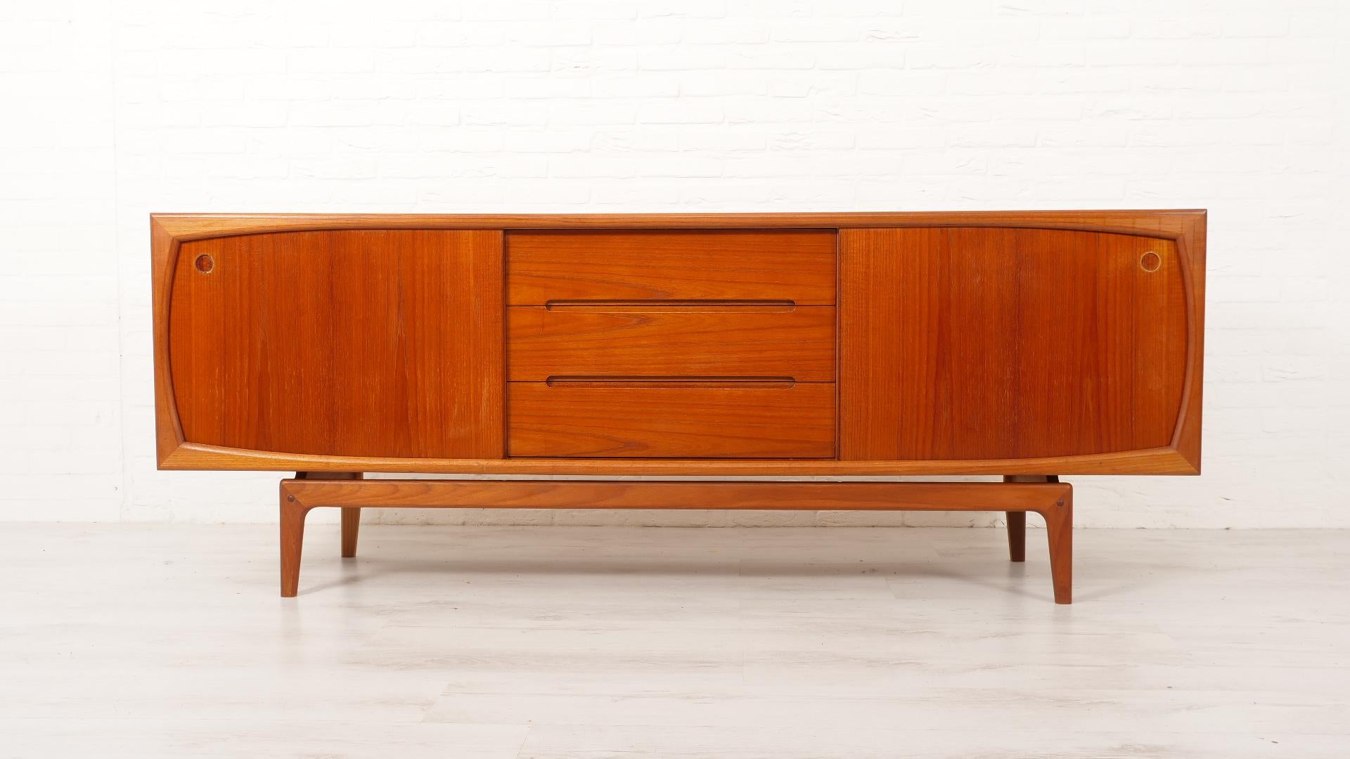 This vintage teak sideboard, believed to have been designed by Arne Hovmand Olsen is a true showpiece from the 1960s. Thanks to its unusual design and craftsmanship, this Danish furniture exudes timeless elegance. The vintage sideboard offers both