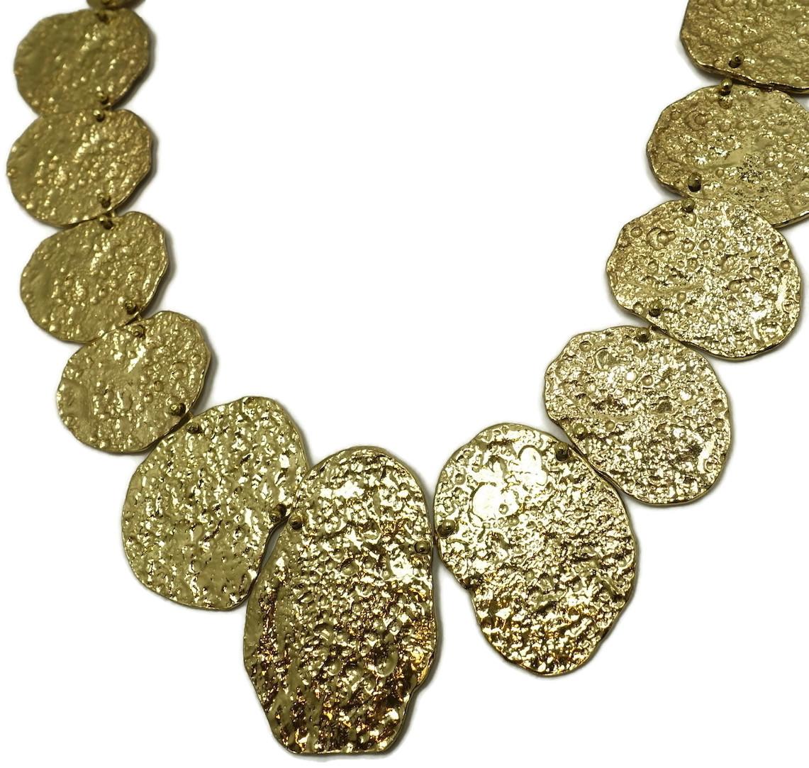 This vintage signed Anne Dick necklace features multiple hammered discs in a gold tone setting.  In excellent condition, this necklace measures 19” with a hook closure. The center disc is 2” x 1-3/8” and is signed “Anne Dick”.