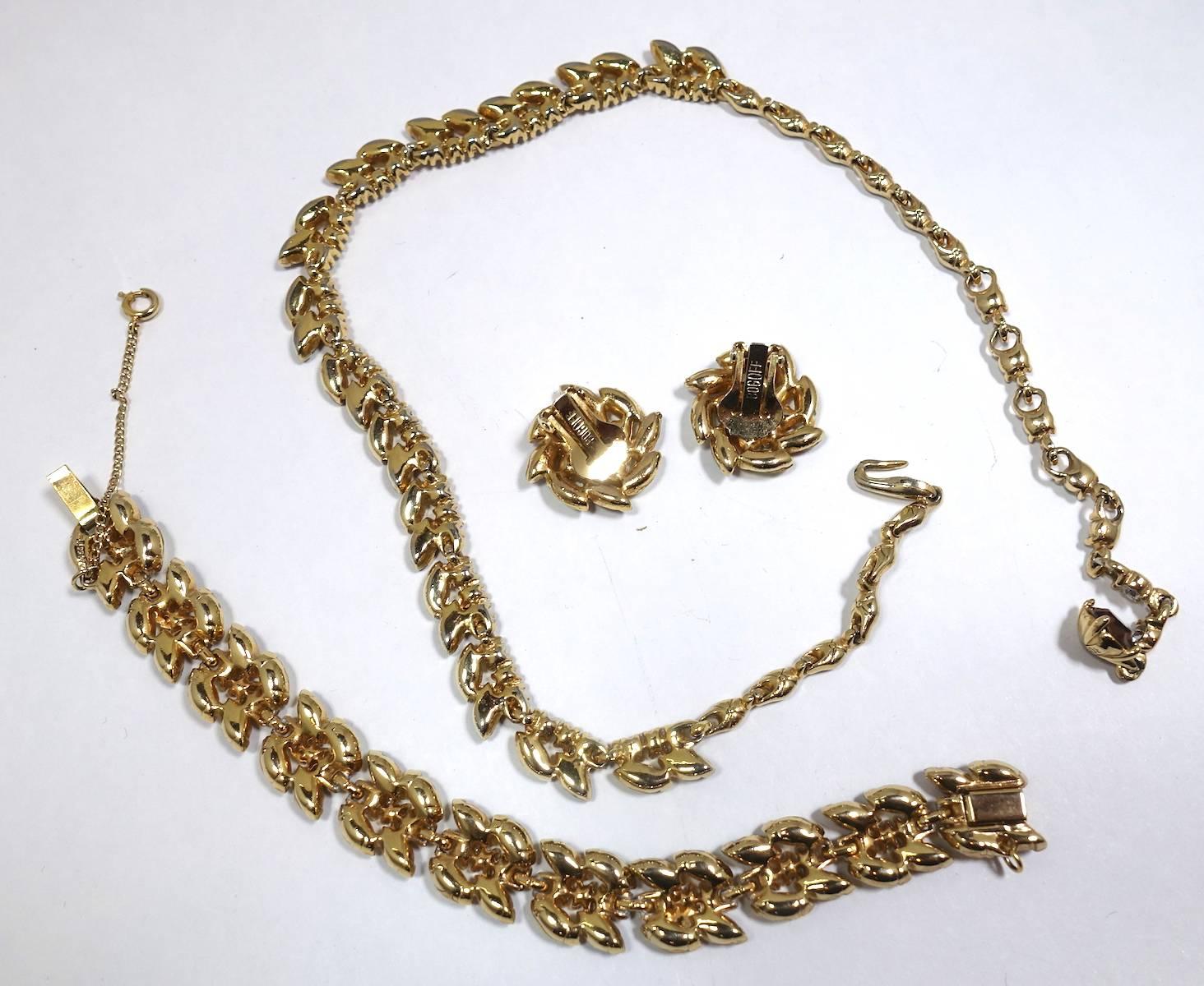 This vintage, highly collectible set by Bogoff features citrine & topaz rhinestones with clear rhinestone accents in a gold tone setting.  The necklace measures 16” x 3/8” with a hook closure. The matching clip earrings are 1” and the bracelet is 7”