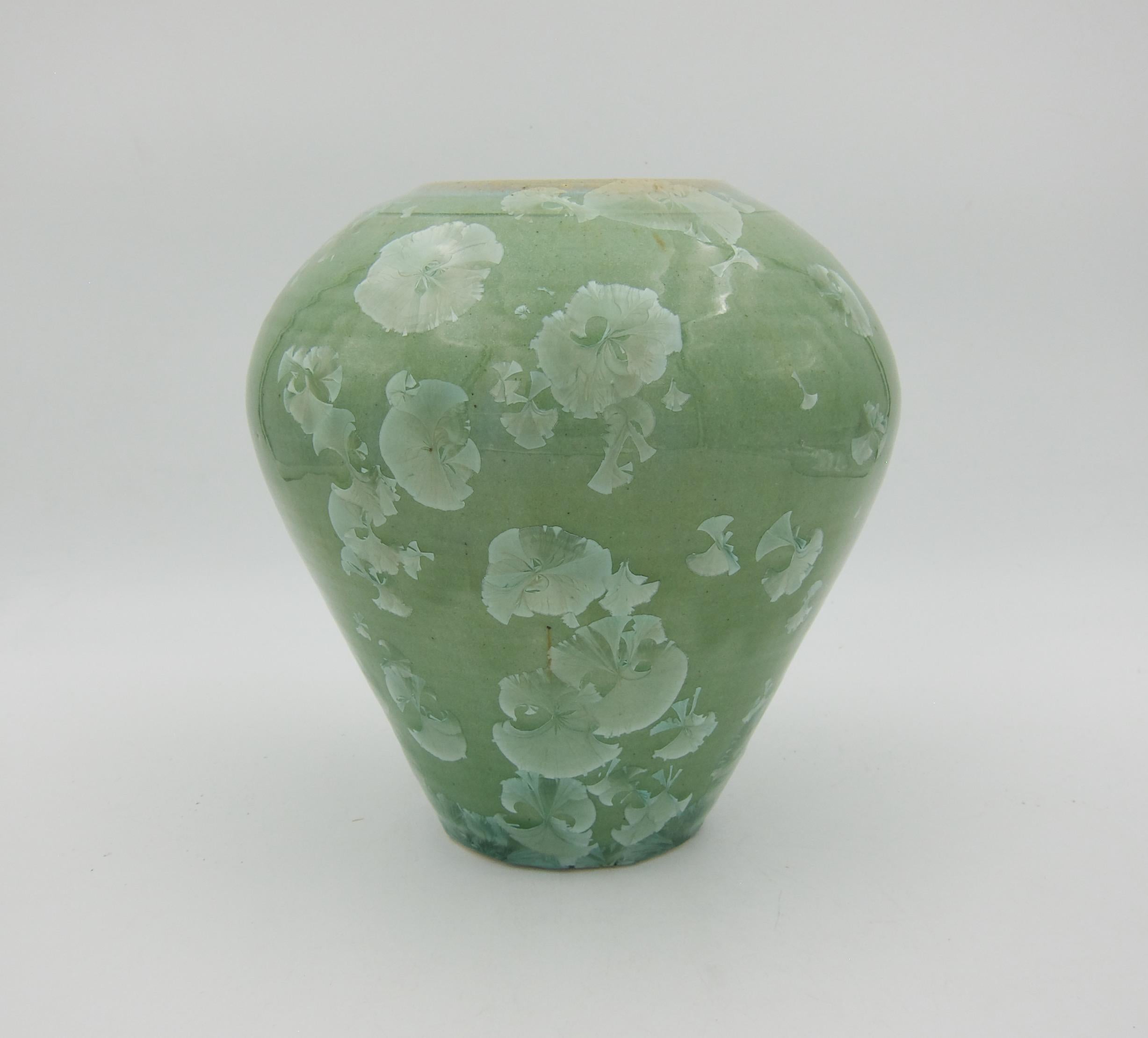 A hand-thrown vintage studio pottery vase from 1987 with a sophisticated crystalline glaze in shades of glossy celadon green with large, overlapping icy crystalline clusters, a few scattered accents in tan and brown. The American potter is Bill