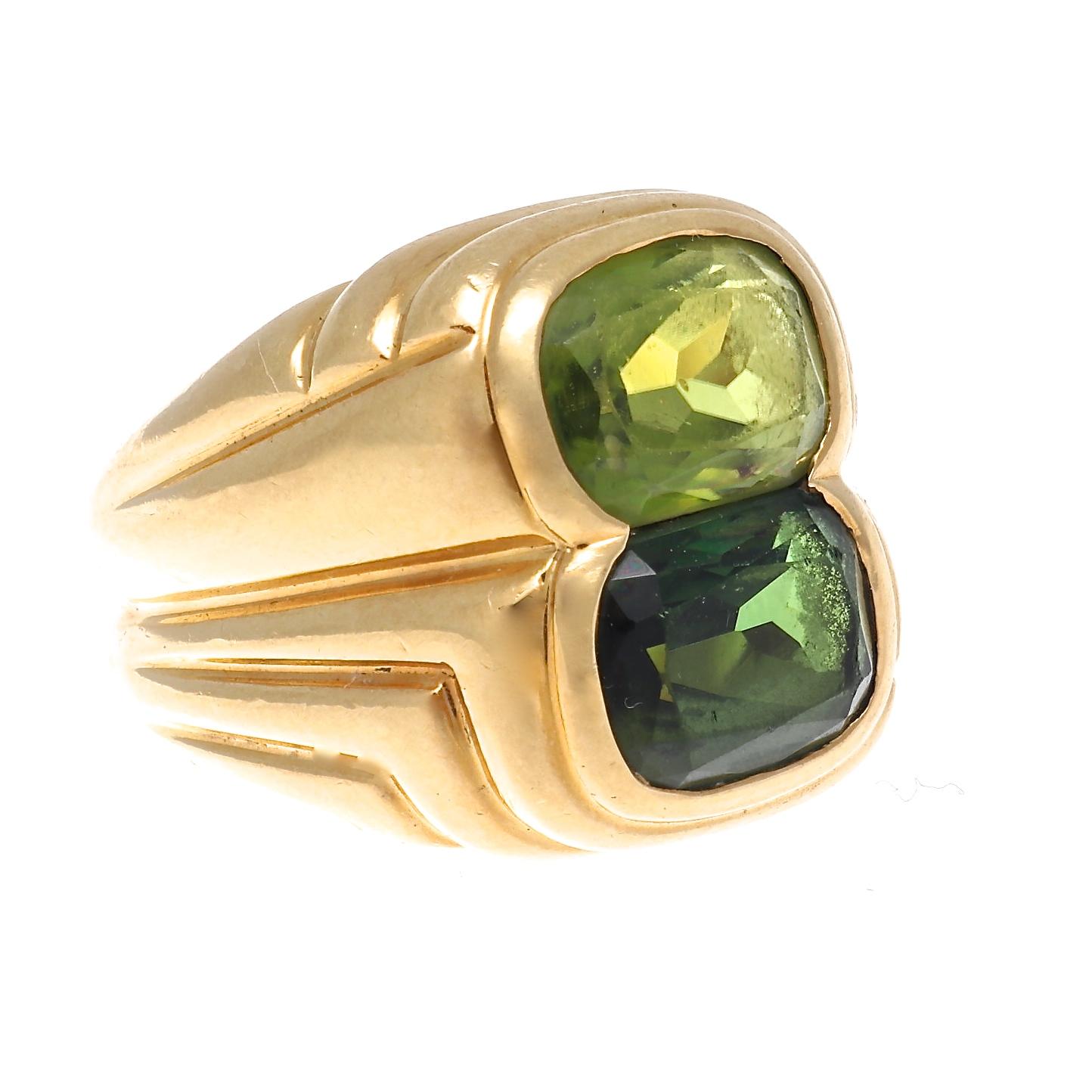 Peridot and green tourmaline ovals are stacked together to showcase their beauty, and are surrounded by iconic Bulgari designed lines in rich 18k gold. Complete with signature and serial number on the inside of the shank. Circa 1990. Ring size 6 1/2