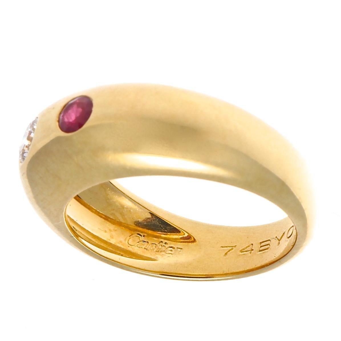 Just what you would expect from Cartier, stylish elegance with beautiful gemstones. Featuring one round brilliant diamond accompanied by two natural round rubies that twinkle with a pinkish red hue. The stones are set in a Gypsy style setting, hence