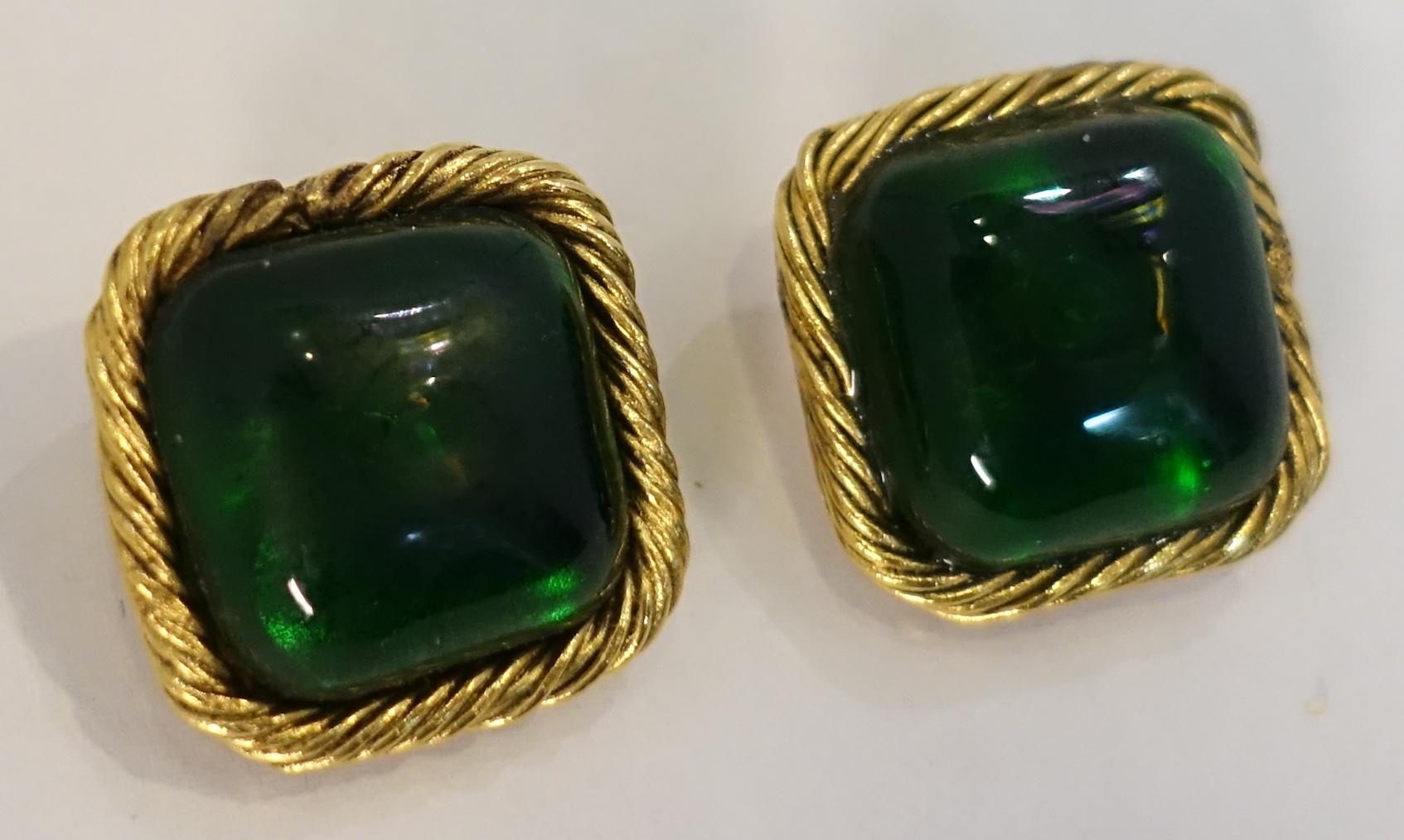 These vintage Chanel earrings are designed with beautiful emerald green Gripoix glass centers bezel into a ribbed gold tone border.  In excellent condition, these clip earrings measure 1” and are signed “Chanel 23 Made in France”.