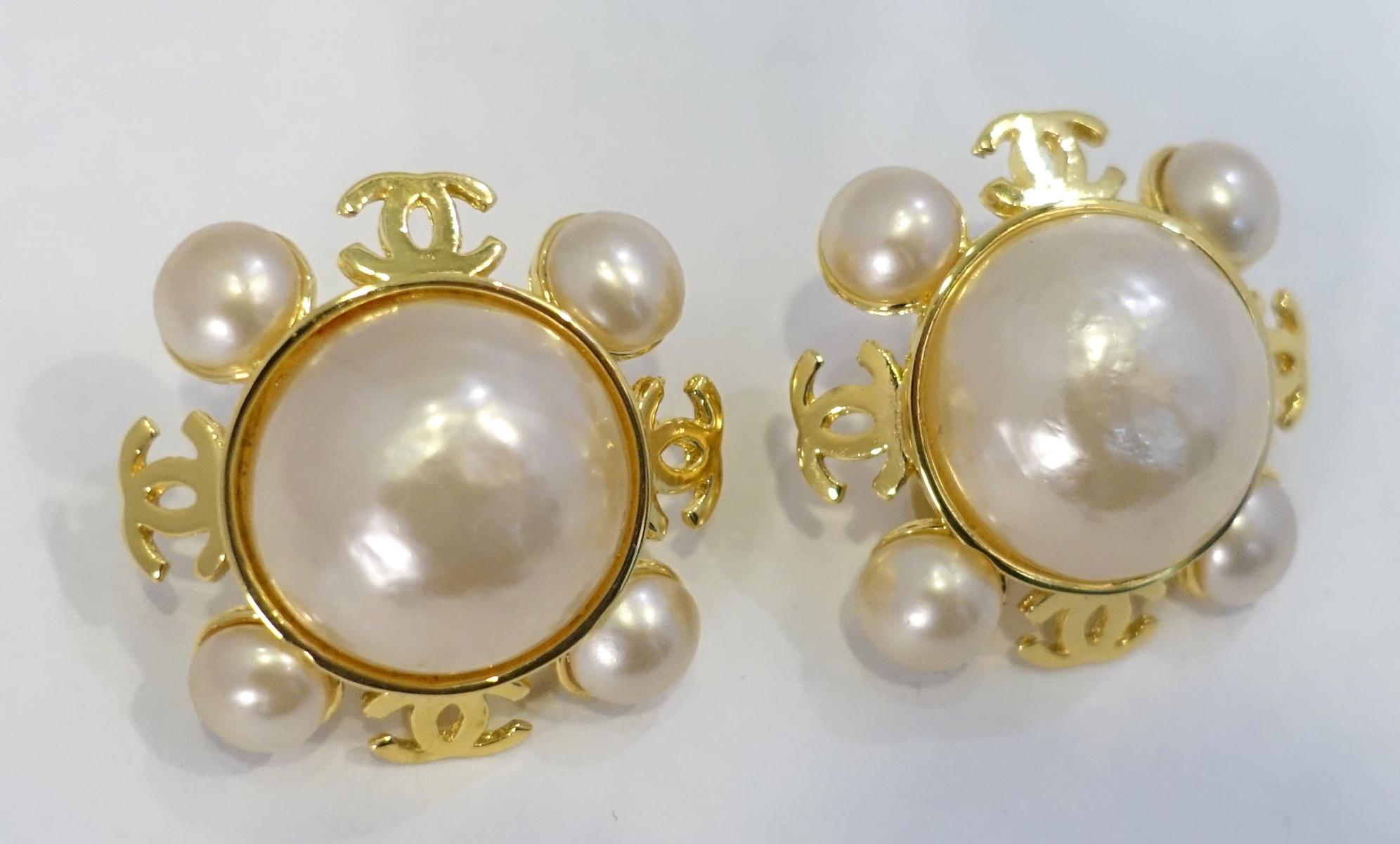 These vintage signed Chanel earrings are designed with faux pearls on the outsides with the double “Cs” in between. A large faux pearl is in the center … all in a gold tone setting.   These clip earrings measure 1-1/2” across and are signed “Chanel
