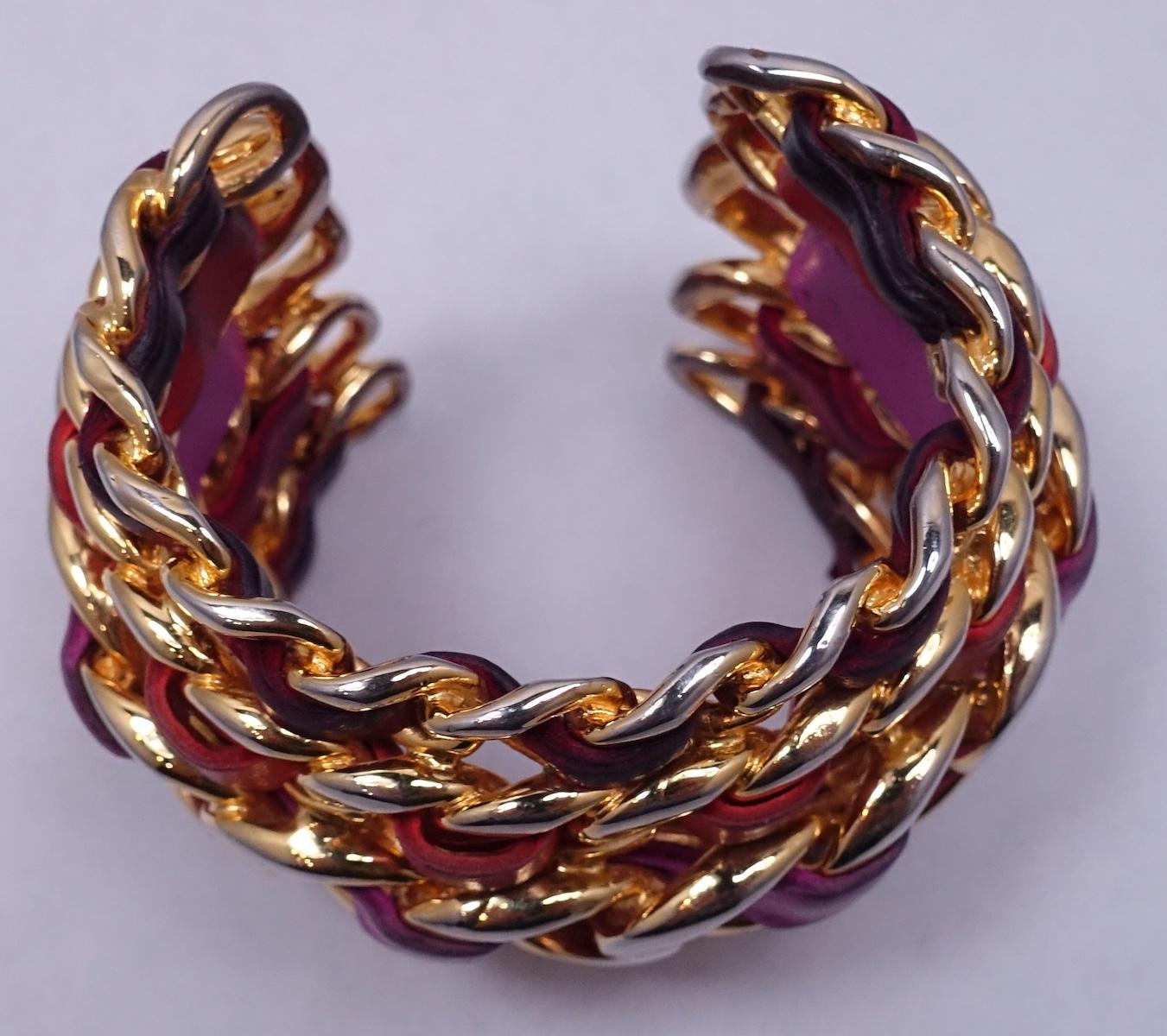 This vintage Chanel runway cuff bracelet has five rows of interweaved lambskin leather in a gold tone and polychrome setting.  The leather colors are lavender, fuchsia, coral and burgundy.  In excellent condition, this cuff is signed “Chanel 26 Made