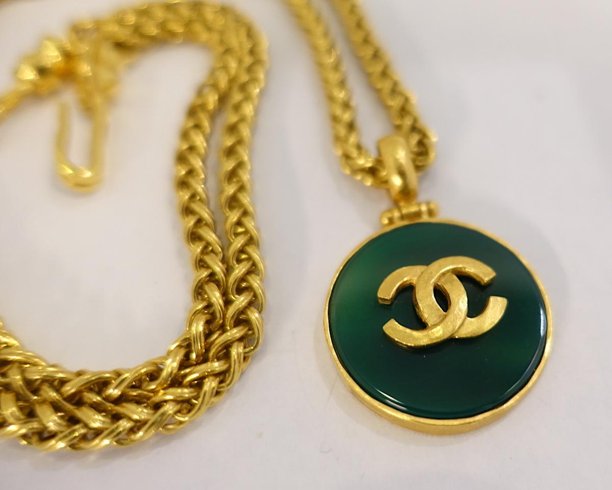 This vintage signed Chanel heavy chain necklace has a green enamel pendant with  Chanel’s famous double “Cs” in the center. The necklace measures 31” long x 1/4” with a spring clasp. The pendant measures 1-1/4” across.  In excellent condition, this