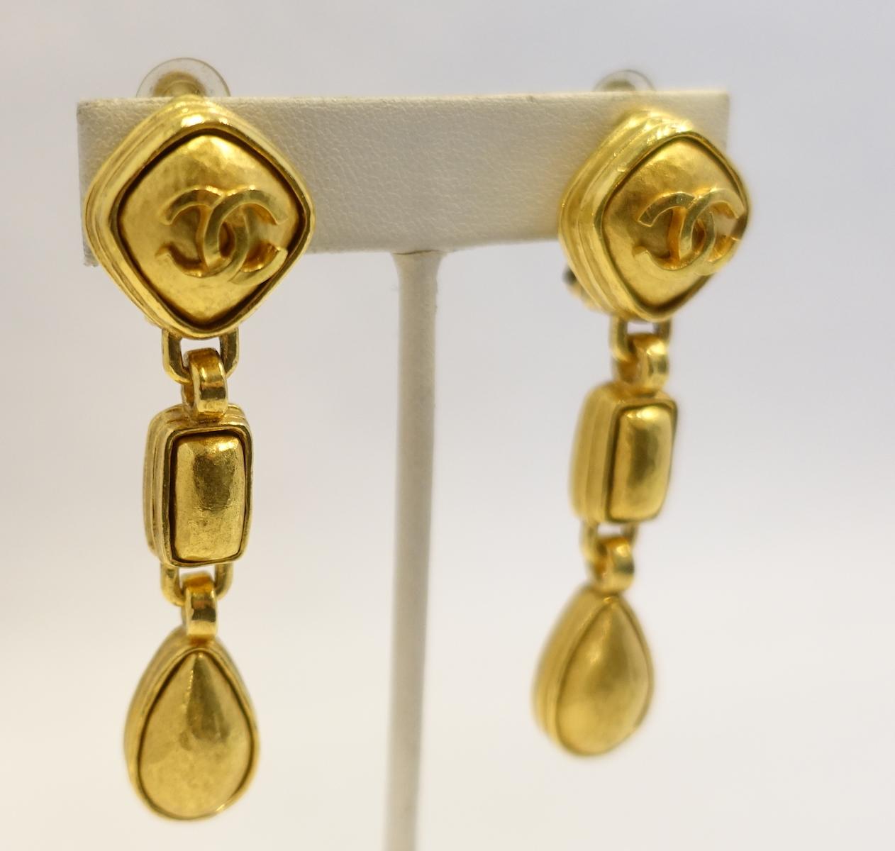 These vintage Chanel dangling earrings have a gold tone triangular top with the double “Cs” in the center. Hanging down are 2 more links … one rectangular shape and then tear drops. These clip earrings measure 2-1/2” x 3/4” and are signed “Chanel