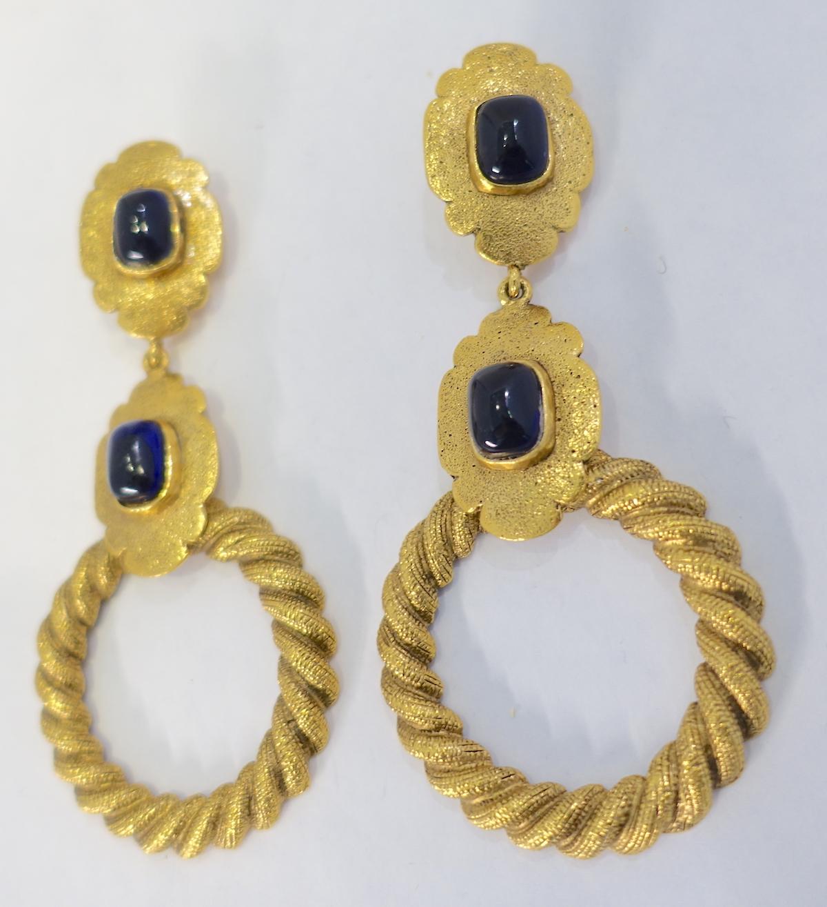 These vintage Chanel ribbed hoop earrings are connected to two gold tone links on top with blue Gripoix glass centers. In excellent condition, these clip earrings measure 4-1/4” x 2” and are signed “Chanel 25 Made in France”.