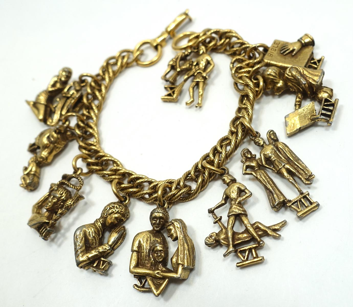 This vintage Coro charm bracelet has the 10 Commandments hanging from an open gold tone link bracelet. The bracelet measures 7” long with a fold-over clasp. The largest charm is 1” x 3/4”.  It is signed “Coro” and is in excellent condition.