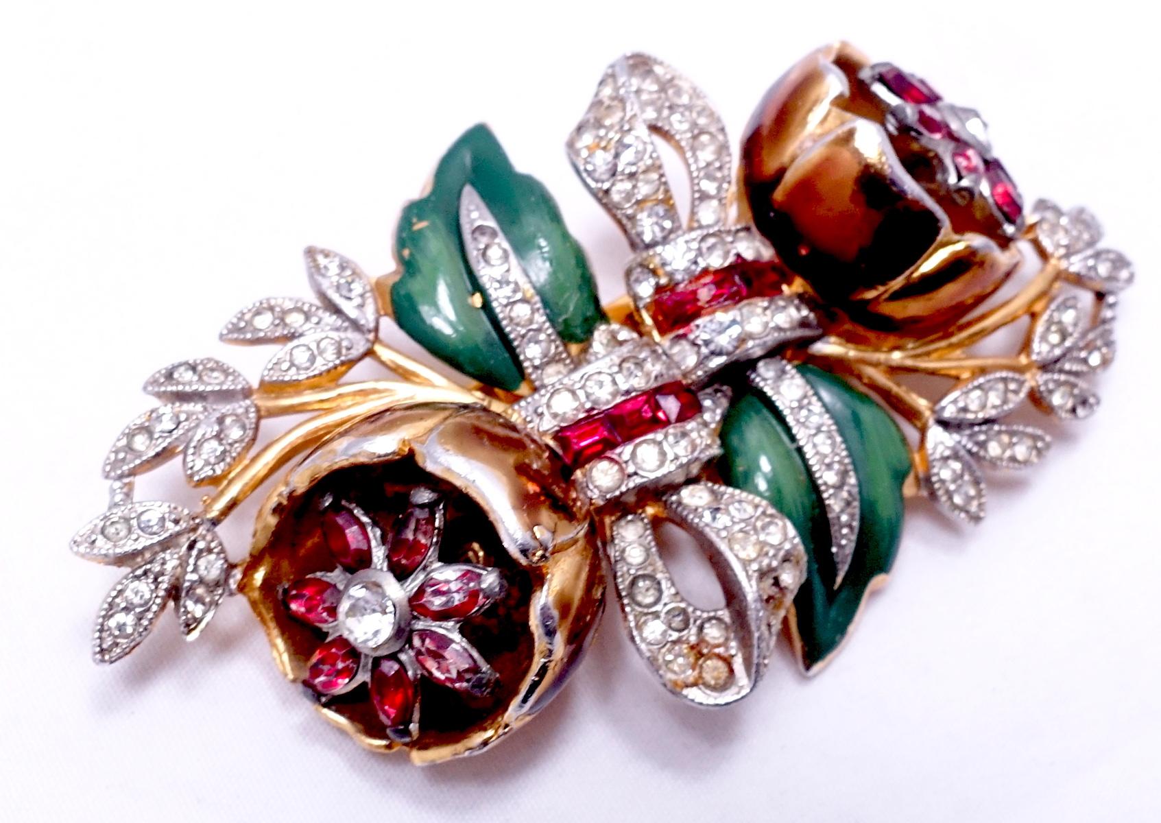 This vintage Coro duette features a floral design with green enameling and red and clear crystal accents in a gold tone setting.  In excellent condition, this piece measures 2-7/8” x 1-1/2” and is signed “Coro Duette”.
