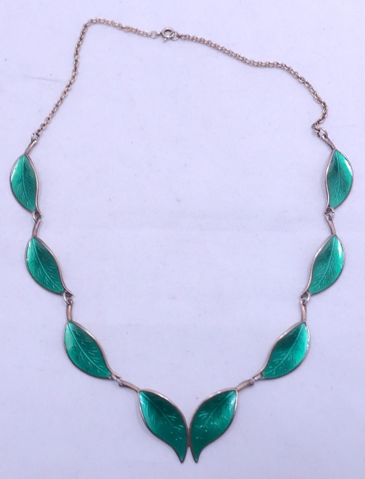 This vintage signed David Andersen necklace features green enameling on a sterling silver/gold wash setting.  In excellent condition, this necklace measures 16” x 1/2” with a spring closure and is signed “D-A 9258 Sterling Norway”.