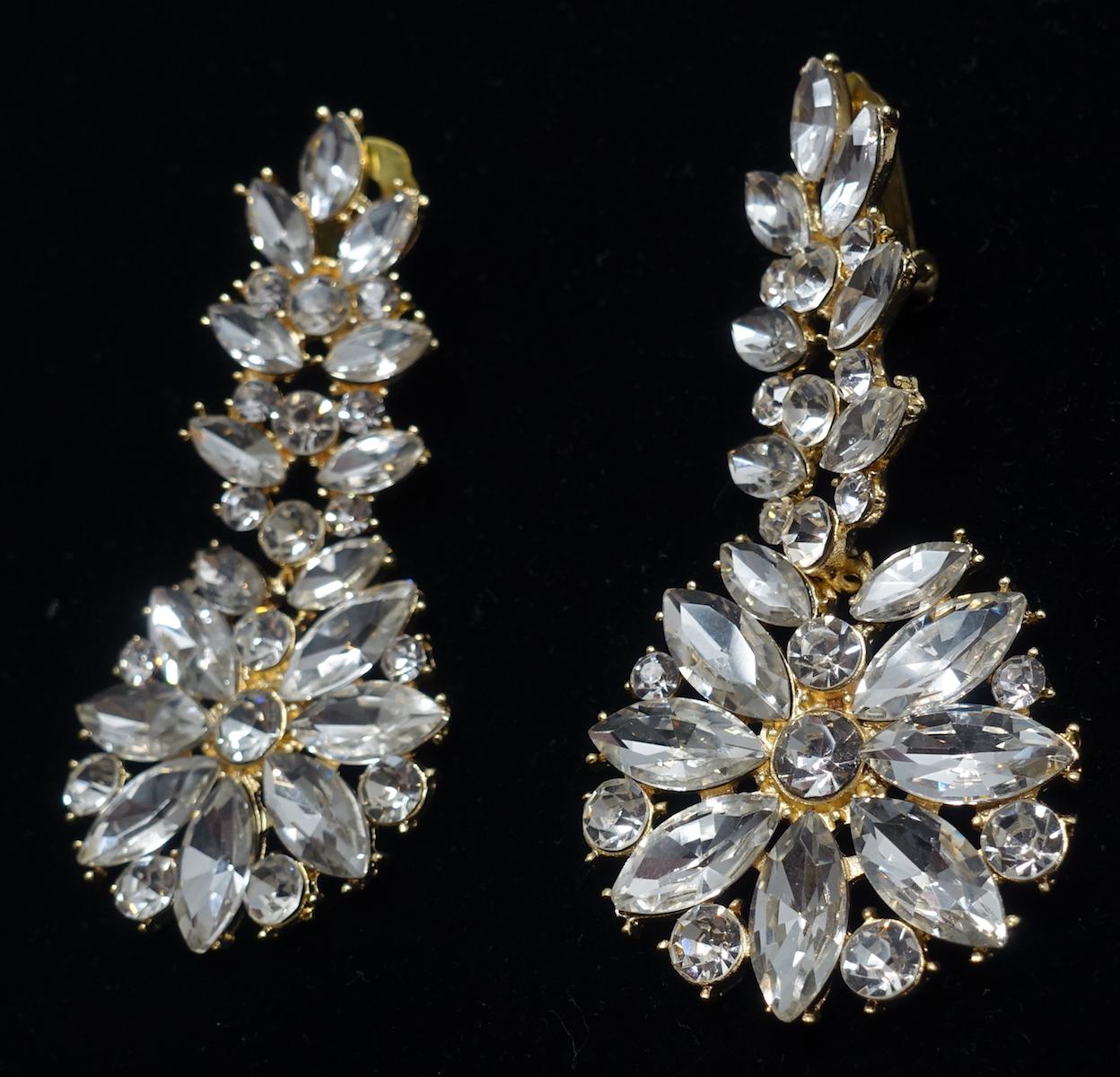 These vintage signed DeMario dangling earrings have clear crystals on top with crystals forming a circle on the bottom in a gold tone setting.  In excellent condition, these clip earrings measure 3” x 1-1/4” and are signed “DeMario”.
