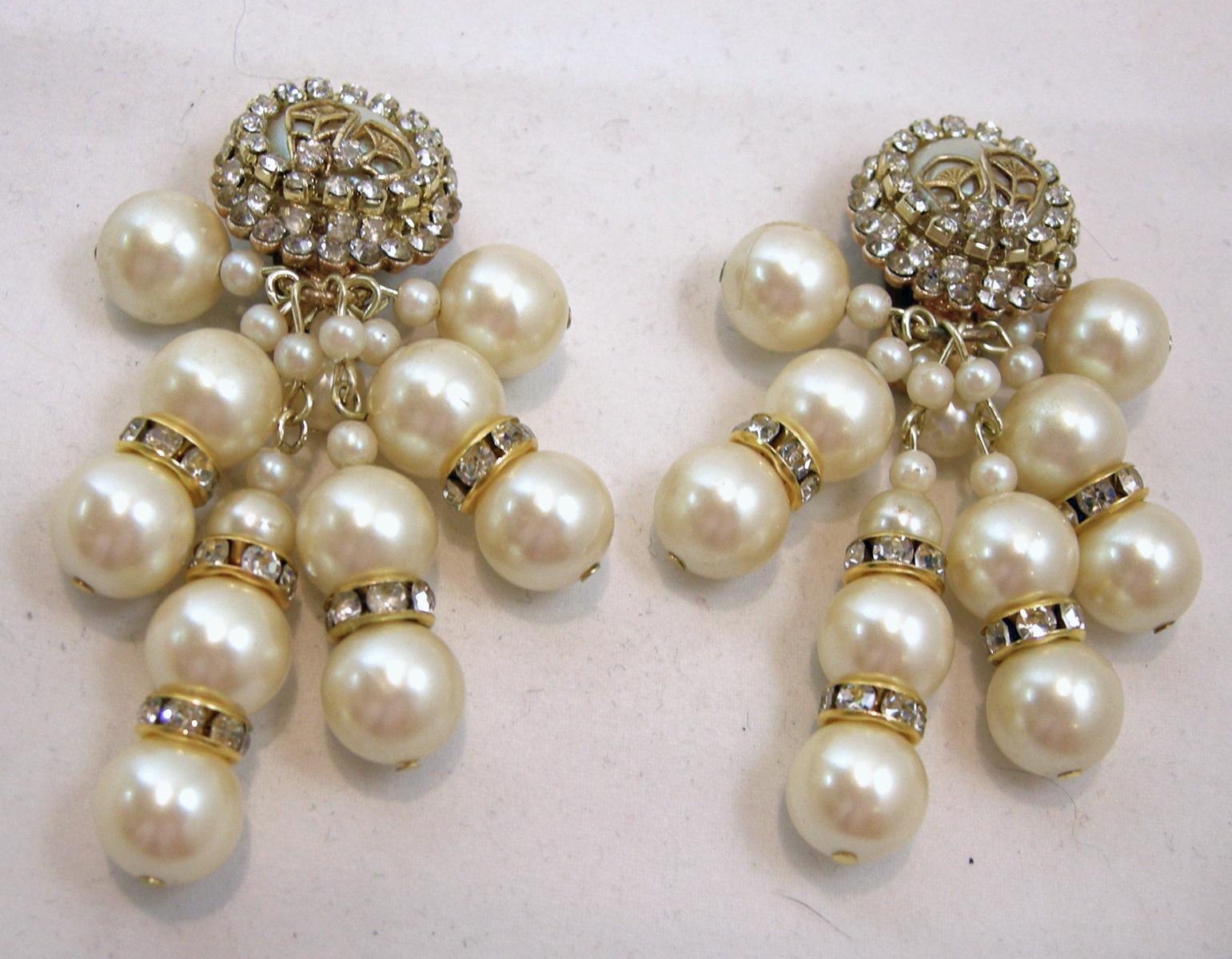 These vintage signed DeMario earrings have faux pearl clusters with clear crystal accents in a gold tone setting.   These clip earrings measure 2-3/4” x 1-1/4 approx. and are signed “DeMario”.  They are in excellent condition.