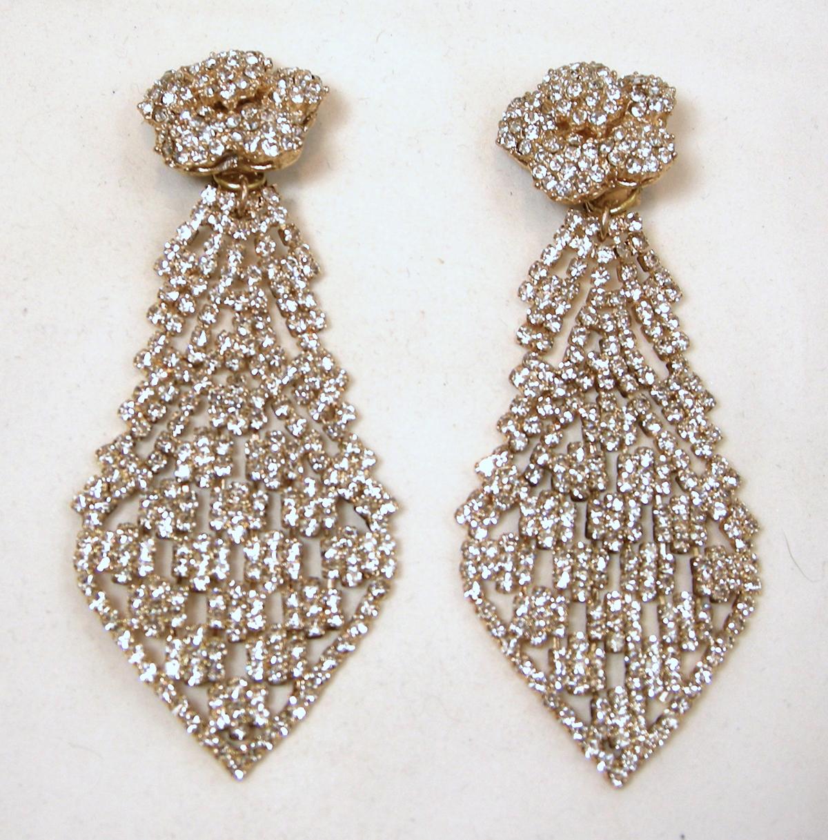 These runway earrings are signed DeMario.  They have a crystal floral top that leads down to a long crystal lace drop in a gold tone metal setting. In excellent condition, these clip earrings measure 4” x 1-1/2” and are signed “De Mario”.