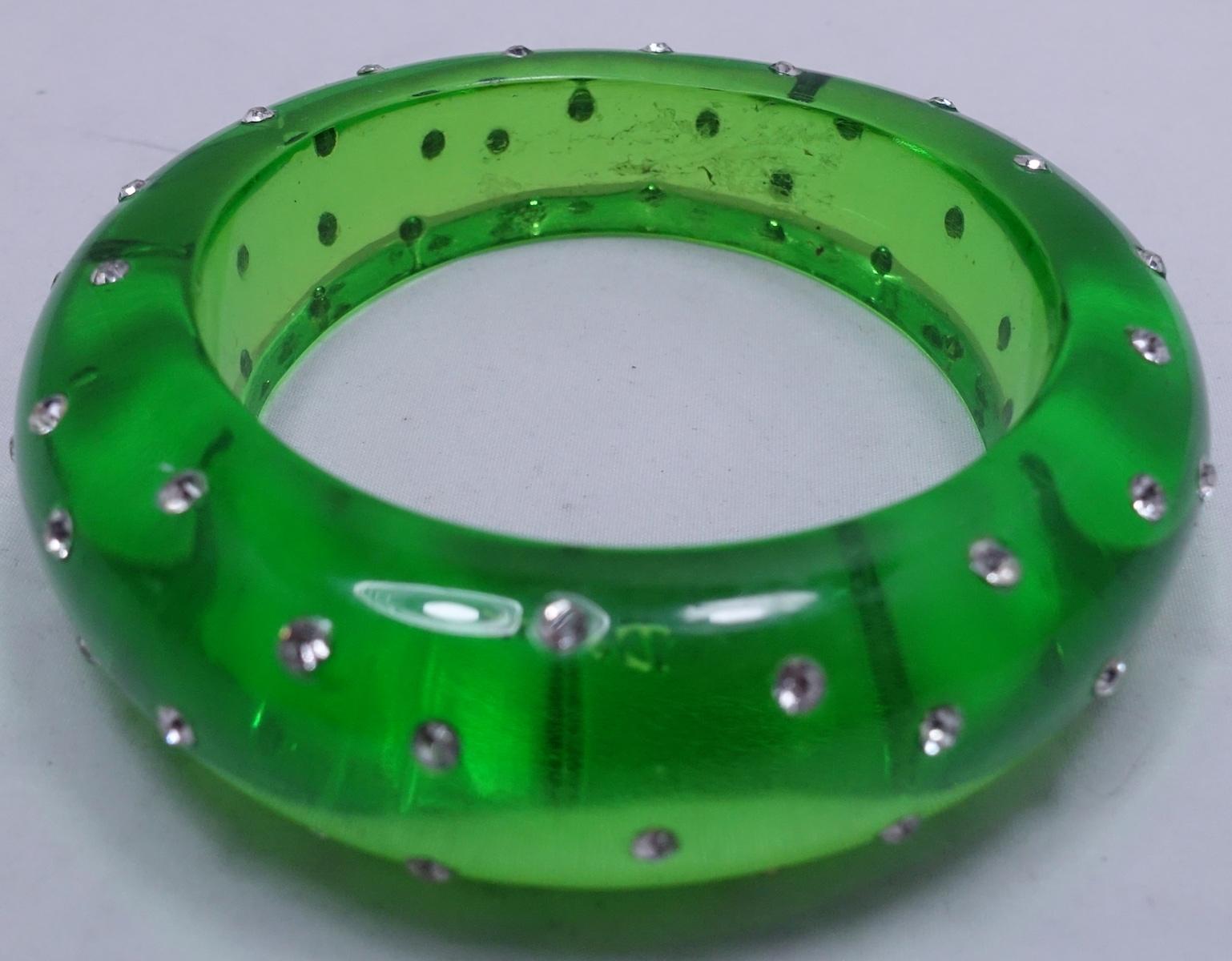 This signed Dereon vintage bracelet features green Lucite with clear crystal accents.  In excellent condition, this bracelet measures 8” around the inside x 3/4” wide and is signed “Dereon”.