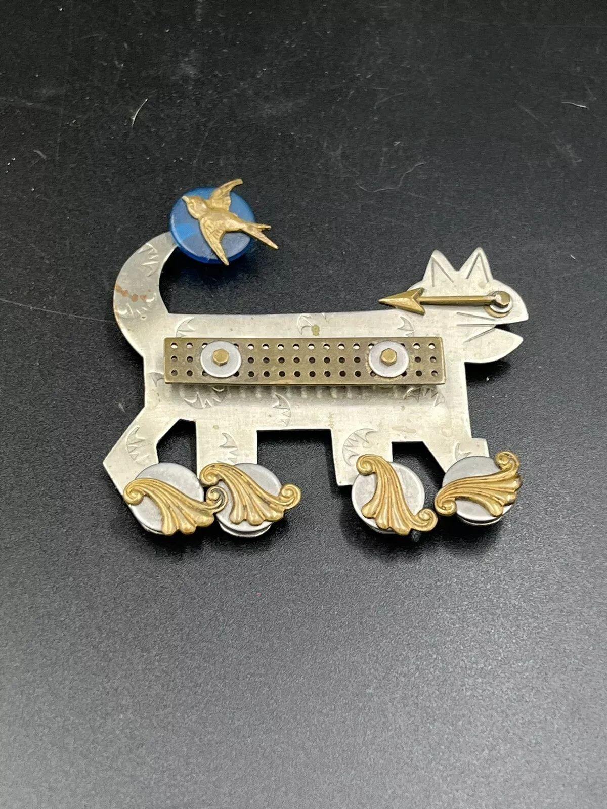 ¡Sencillamente maravilloso! Alfiler broche con forma de gato y pájaro en patines del diseñador Thomas Mann. Metal Art artesanal y bien detallado que utiliza metales mixtos de latón, plata y bronce. Mide aprox. 2,75