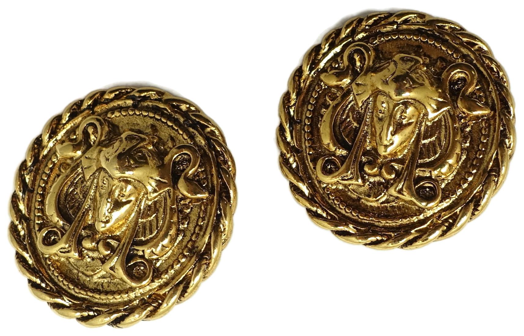 These vintage earrings feature a Medusa image carved into a gold tone metal setting.   In excellent condition, these clip earrings measure 1” across and are signed “Erwin Pearl”.
