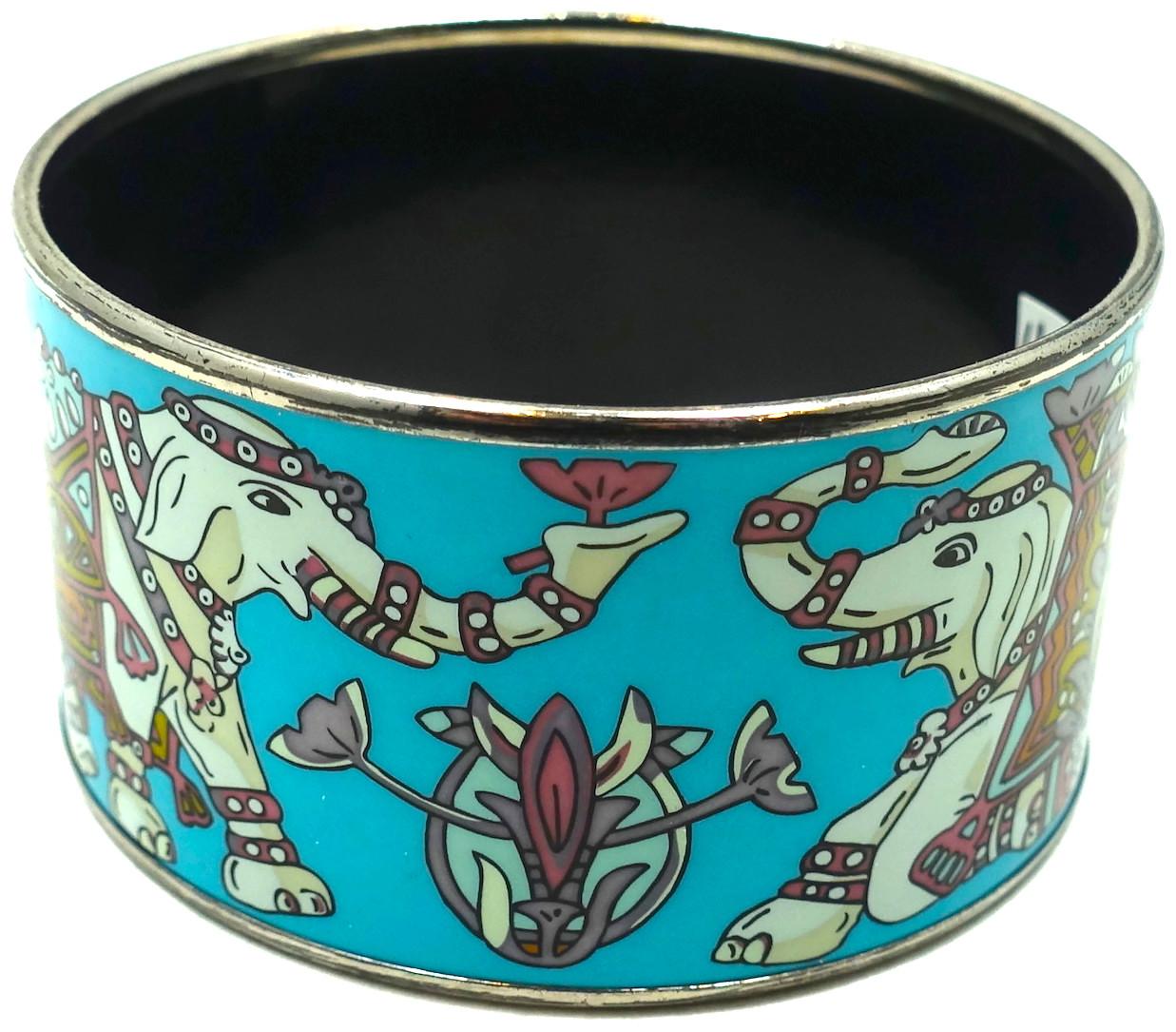 This famous wide vintage signed Hermes elephant cuff bracelet is in demand by collectors.  It has elephants with their trunks up going around the cuff. It has multi-color enameling with a silver tone trim.  In excellent condition, this bracelet