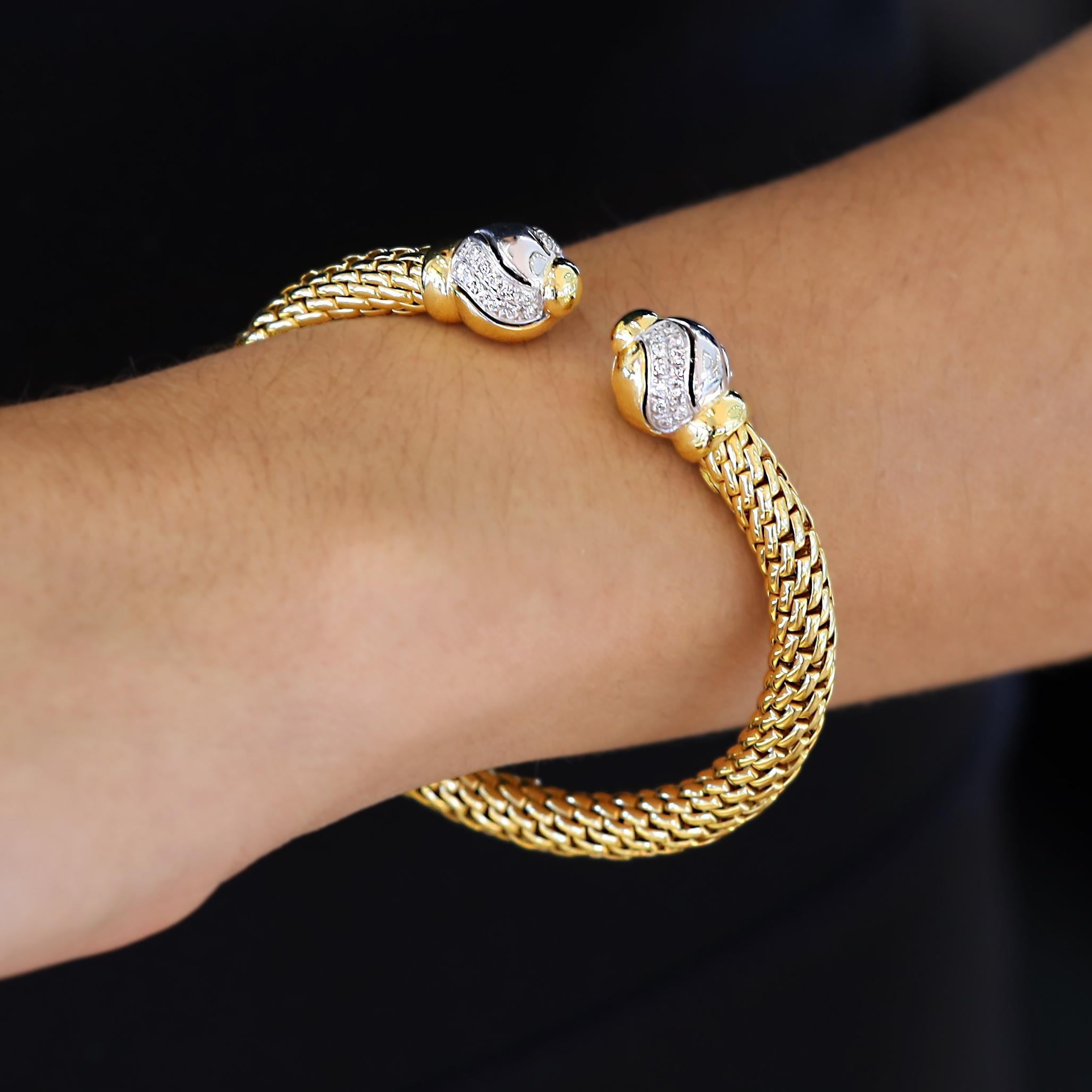 Ein tolles, flexibles Manschettenarmband aus 18 Karat Gold von der renommierten italienischen Goldschmiede FOPE. Die eleganten, zweifarbig funkelnden Diamantkugeln an der Öffnung ermöglichen es Ihnen, diesen luxuriösen Armreif mühelos an Ihr