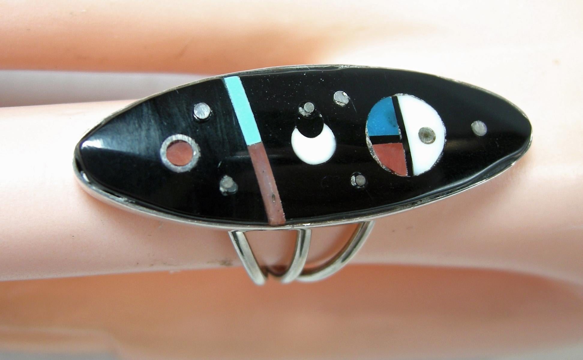 This vintage signed H. Smith elongated ring has an onyx stone with inlay of turquoise, coral and Mother of Pearl in sterling silver.  It’s a size 6-1/2 and measures 1-1/2” x 1/2” at the top. It’s signed “H. Smith” and is in excellent condition.