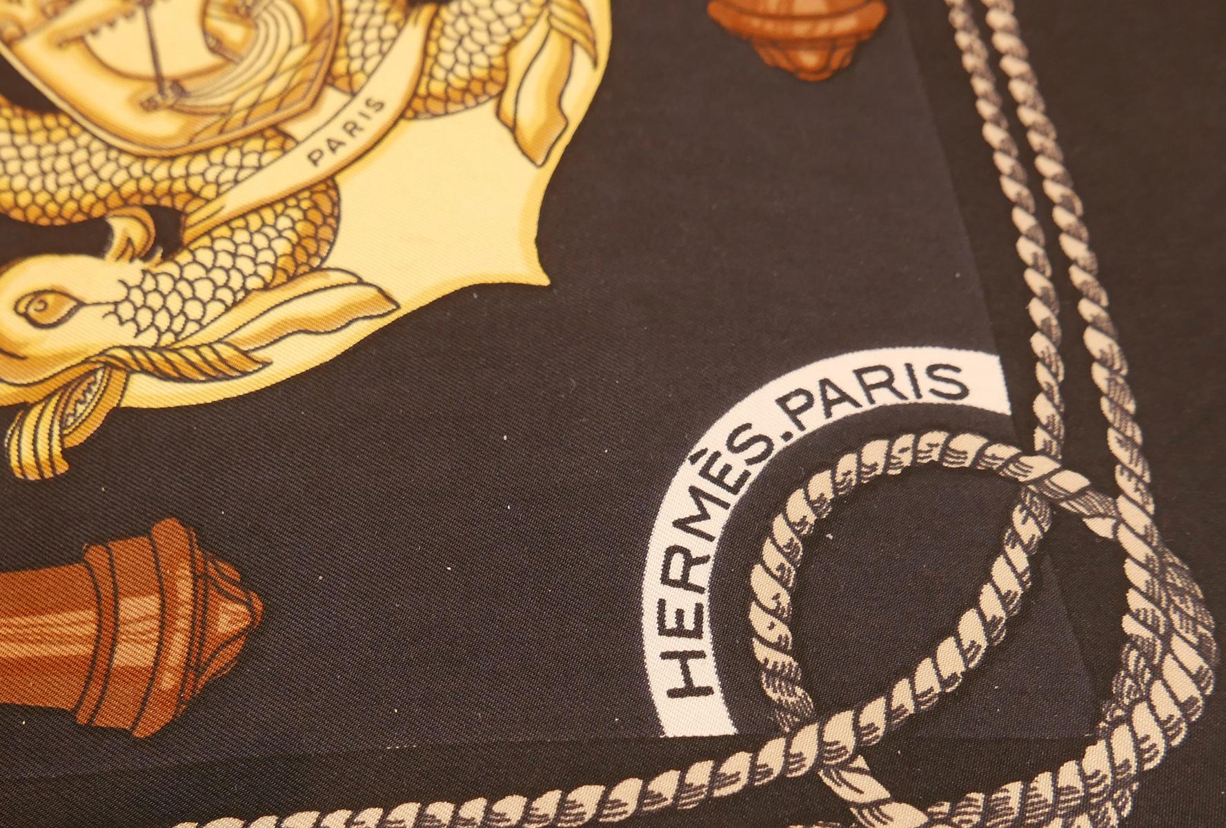 This vintage Hermes scarf, “Coaching”, originally designed by Christane Vauzelles, features a nautical design with ships and anchors on a black background.  In excellent condition, this silk scarf measures 35” square and is signed “Hermes Paris”.