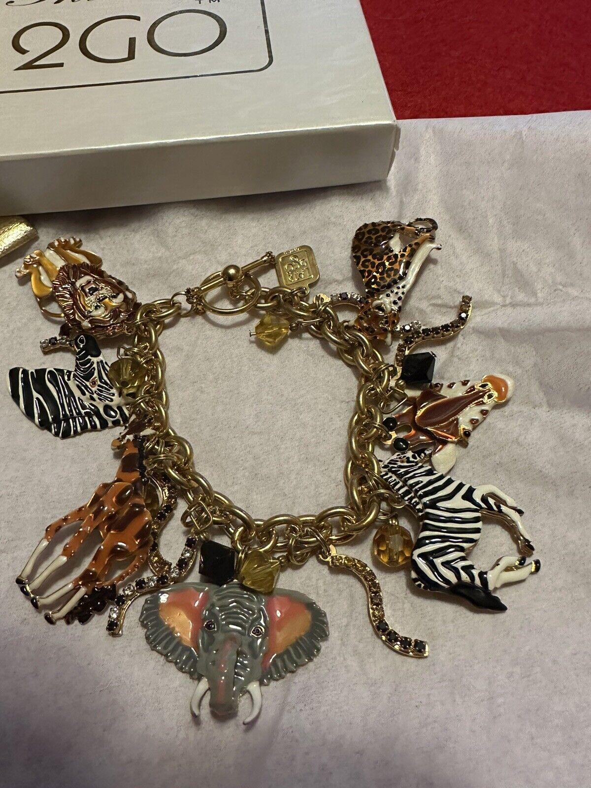 Simply Wonderful! Vintage Statement Signed Lunch at the Ritz 2GO Safari Gold tone Link Charm Bracelet. Brimming with Enamel Multi Charms. Featuring a Zebra, Elephant, Lion, Cheetah, Giraffe. Toggle clasp. Charms and beads vary in size.  Measuring