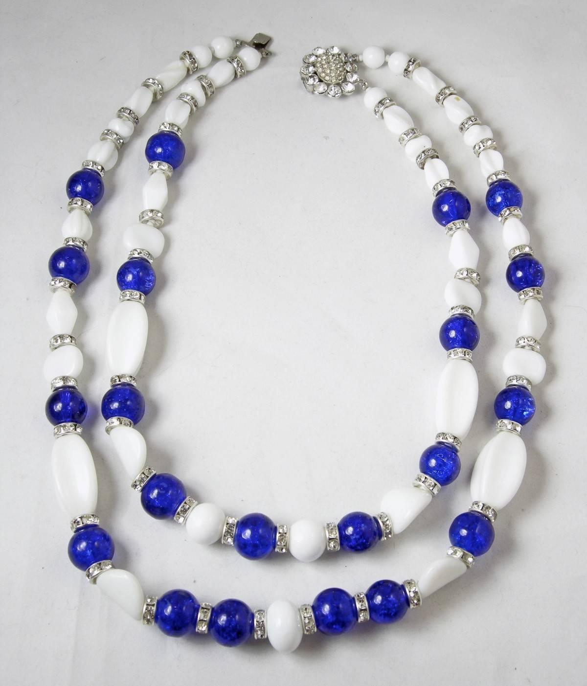 This wonderful signed Marquise blue glass necklace has 2 rows of various shaped glass … including round, oval and elongated melon shaped. The necklace has rondel spacers in-between each glass and graduates in size as it goes downward. The necklace