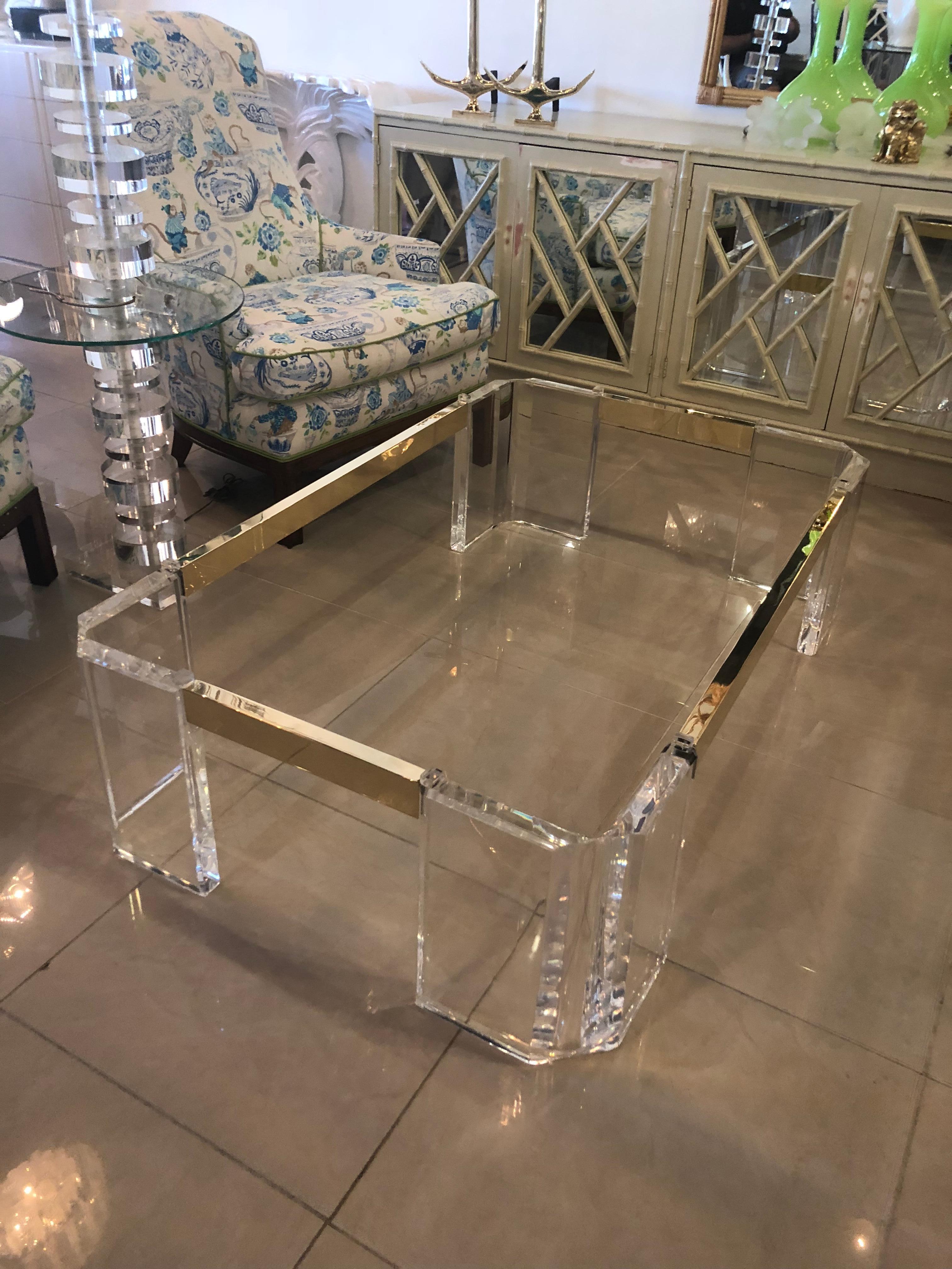 Amazing vintage Lucite and brass coffee cocktail table. The Lucite and brass have been professionally polished. The glass is being newly cut and will be 3/8” thick and following the edge of the tabletop. This is a substantial 
table. Signed Michael