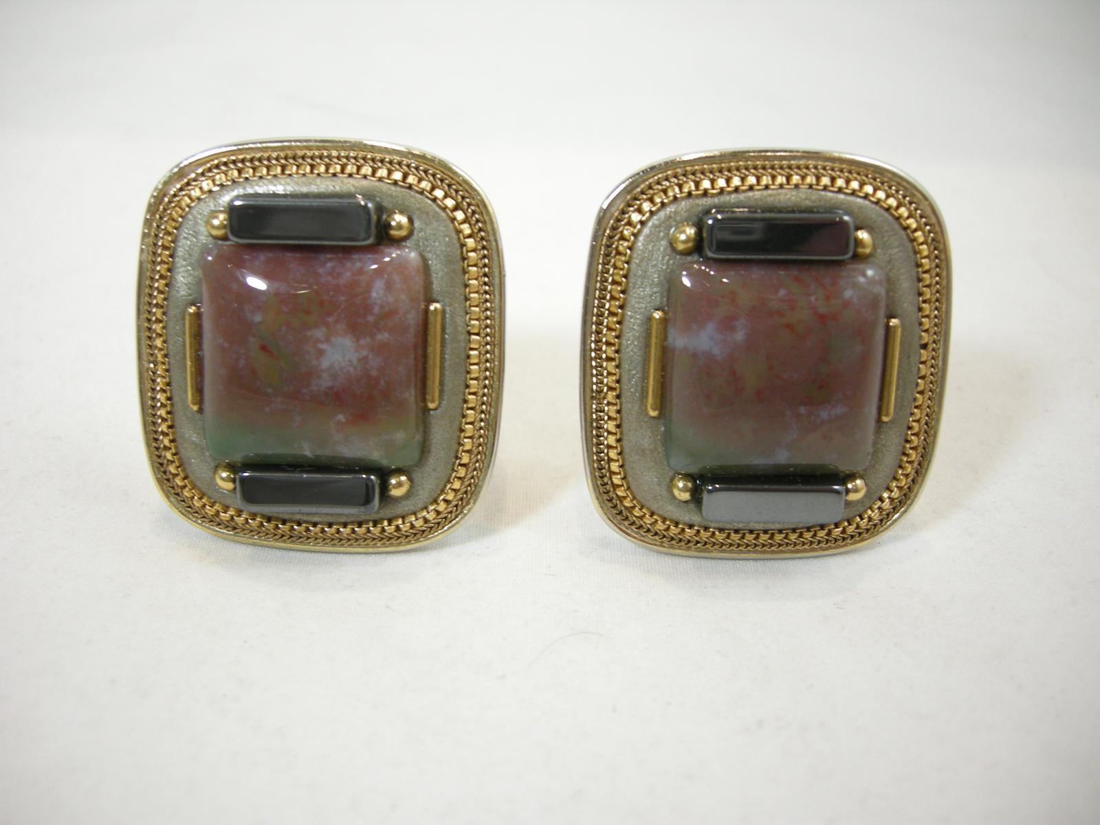 These vintage signed Michal Golan earrings has a marbleized center stone with hematite and enamel accent in a gold tone setting.  In excellent condition, these clip earrings measure 1-1/2” x 1-1/4” and are signed “Michal Golan”.