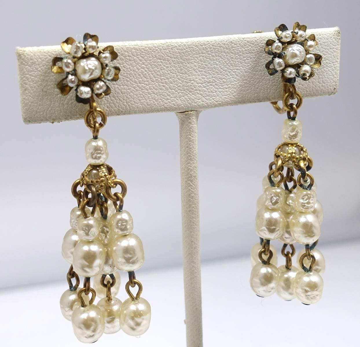 These vintage signed Miriam Haskell earrings feature baroque faux pearls in a gold tone metal setting.  The earrings measure 2-1/8” x 3/4” and signed “Miriam Haskell”.  They are in excellent condition.