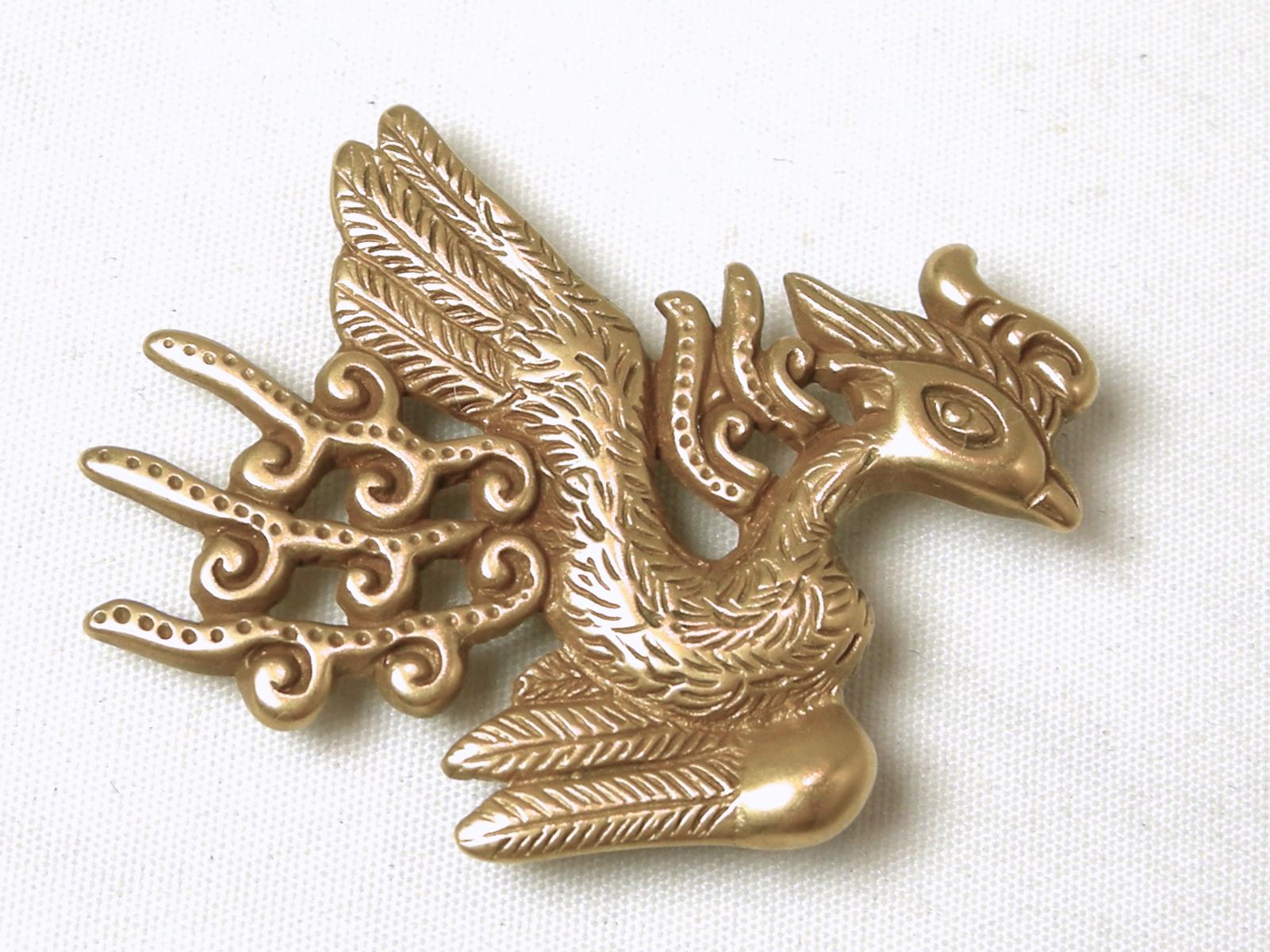 This signed MMA 1980 Metropolitan Museum of Art brooch has a phoenix bird design.   In excellent condition, this brooch-pendant measures 1-1/2” x 1-1/4” and is signed “MMA 1980”.  It also comes with the original box and info card.  