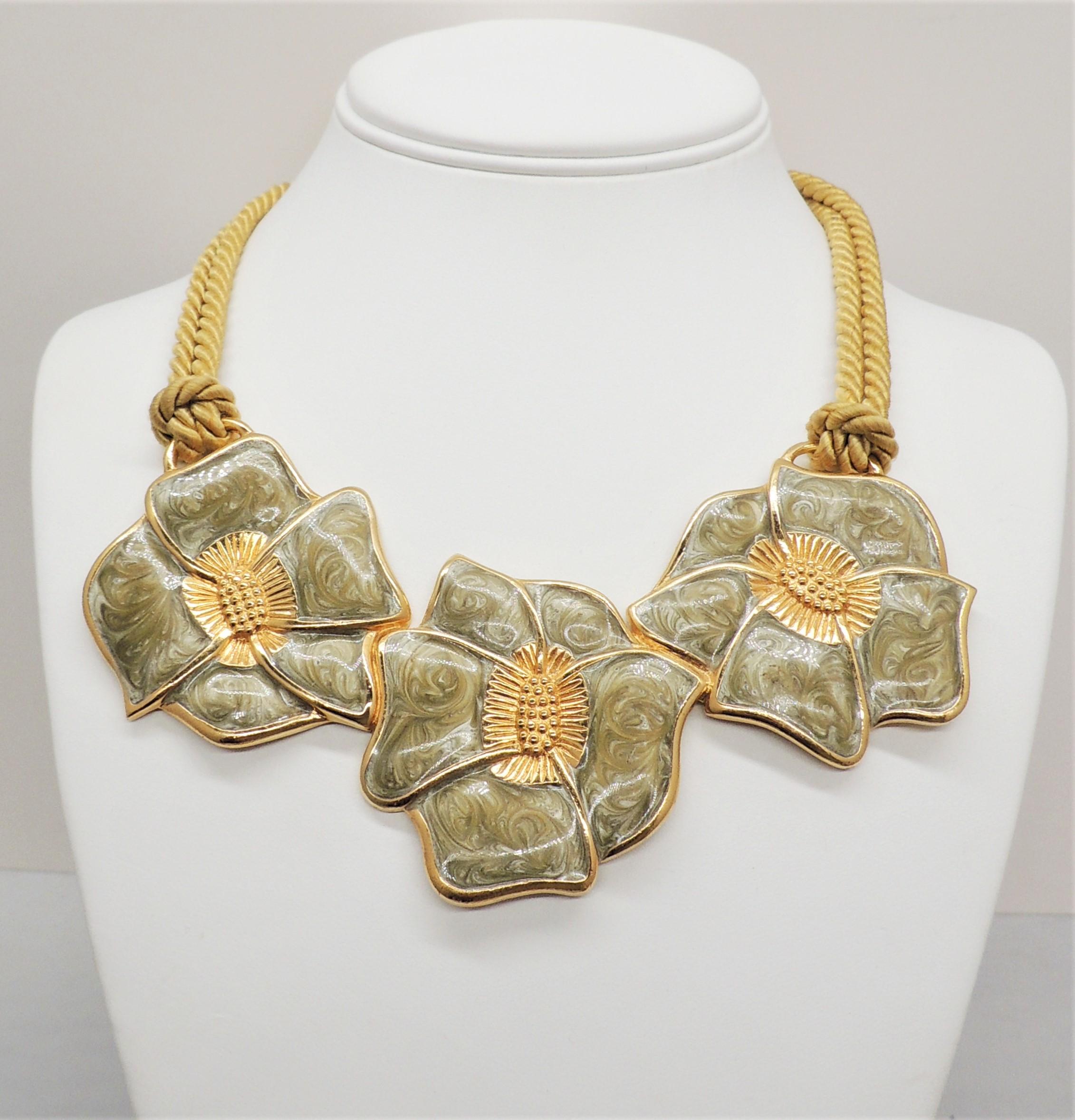 Goldfarbene, irrlichternde, blaue, wirbelnde Halskette mit drei Blüten, geflochtener Seidenkordel und Hakenverschluss. Gekennzeichnet mit 