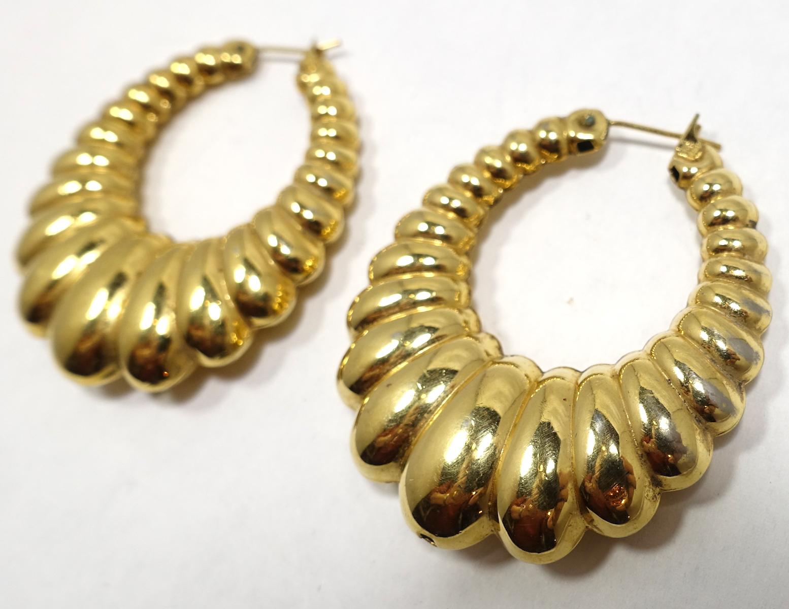 These vintage Monet hoop earrings have a detailed shrimp ribbed design in a gold tone metal setting. These pierced earrings measure 2” x 1-5/8” and are signed “Monet”.  They are in excellent condition.