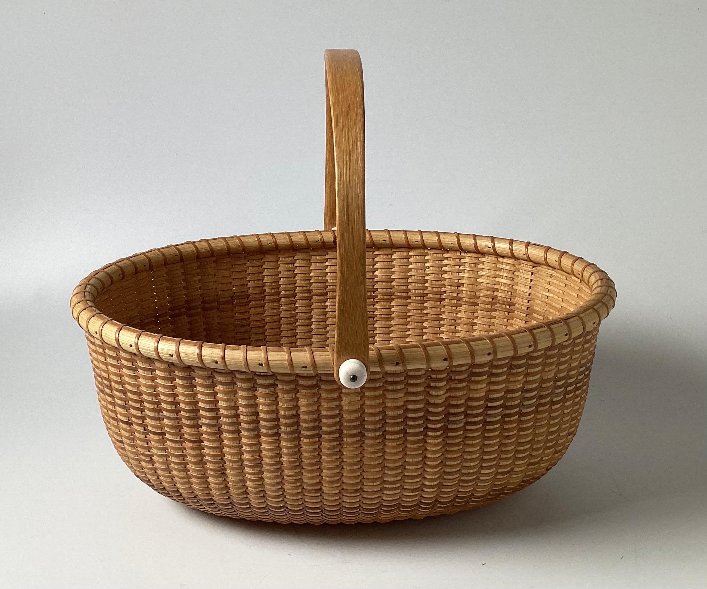 A beautifully crafted Nantucket basket with handle, signed on the underside Susan Chase Ottison. 