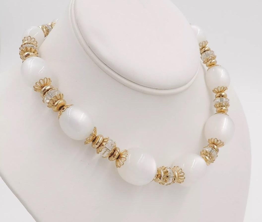 1950s Napier goldtone white moonglow Lucite bead necklace with cut-glass spacers and hook clasp. Marked 