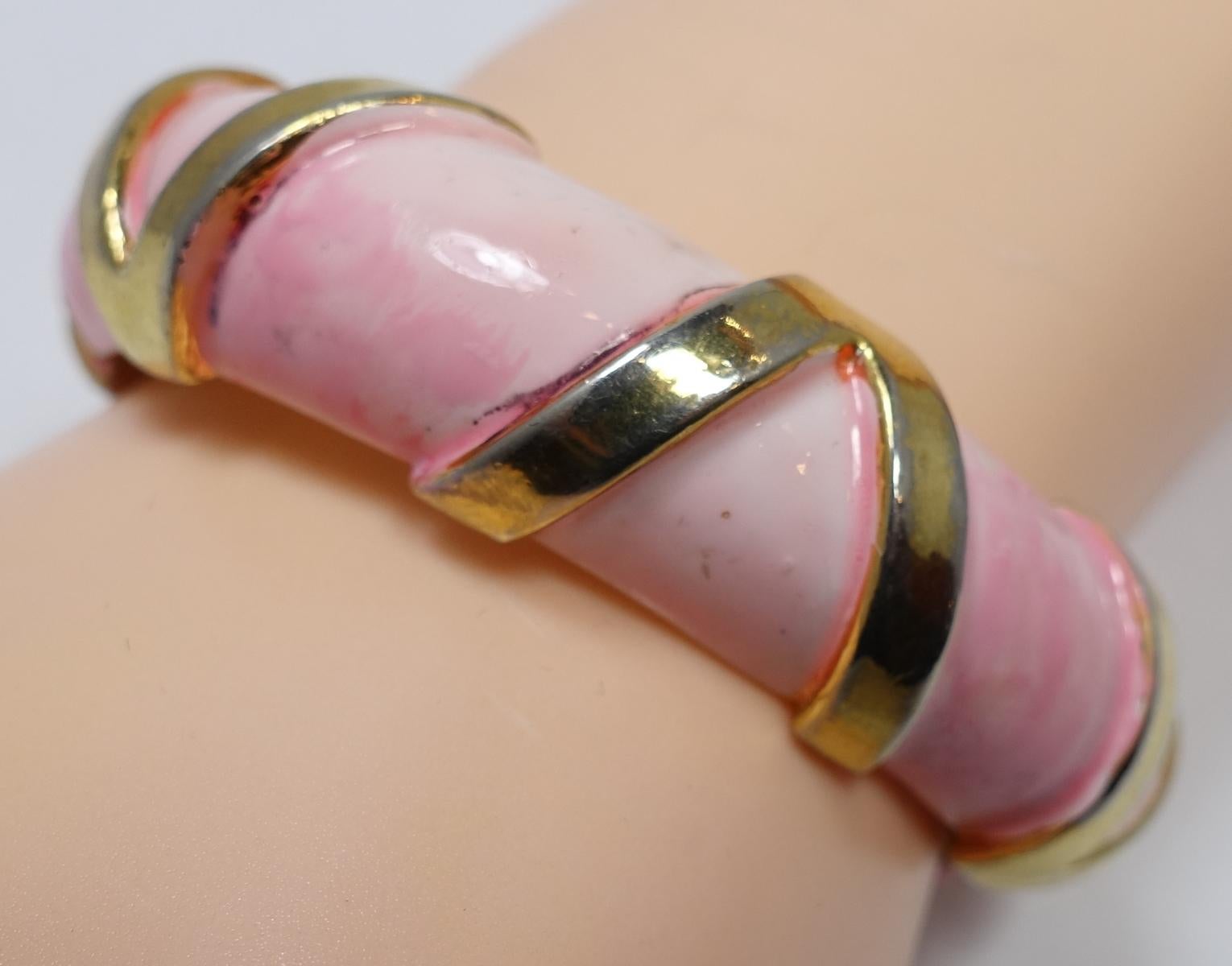This vintage signed Robert bracelet features a pale pink/coral enameling with gold tone bars on top.  In excellent condition, this bracelet measures 6-1/2” around the inside x 5/8” and is signed “Original by Robert”.
