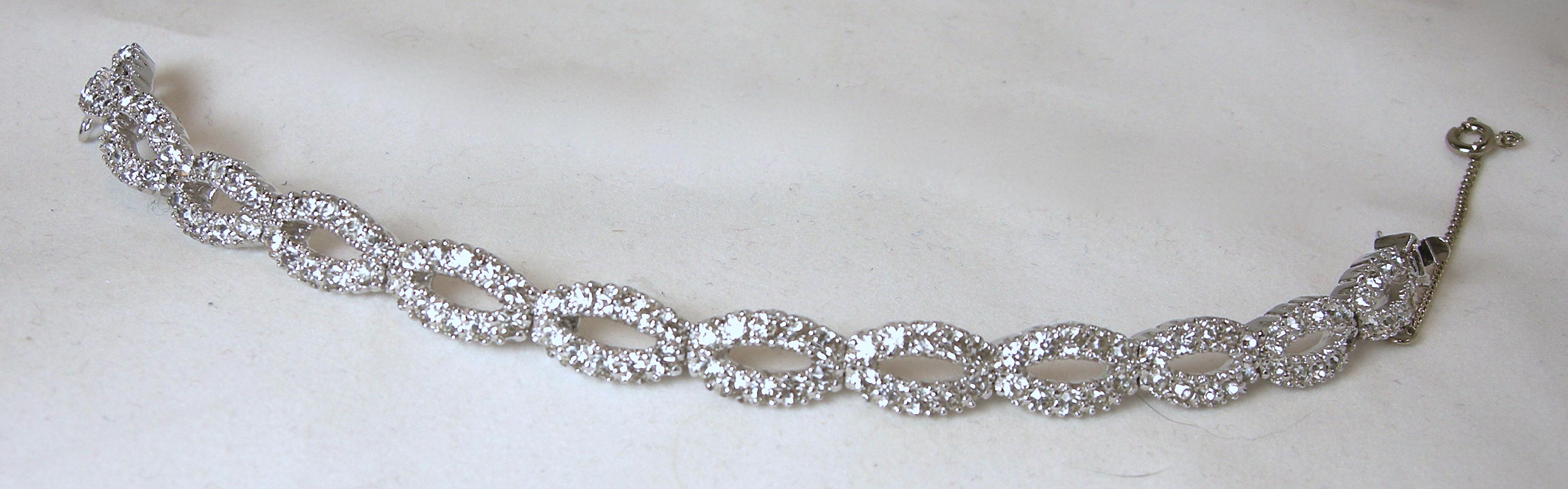 This vintage Panetta crystal bracelet was made to look real and it does.  Bright, brilliant crystal oval links go completely around. It has a slide-in clasp in a rhodium silver tone setting.  It measures 6-1/2” long x 3/8” wide with a safety chain. 