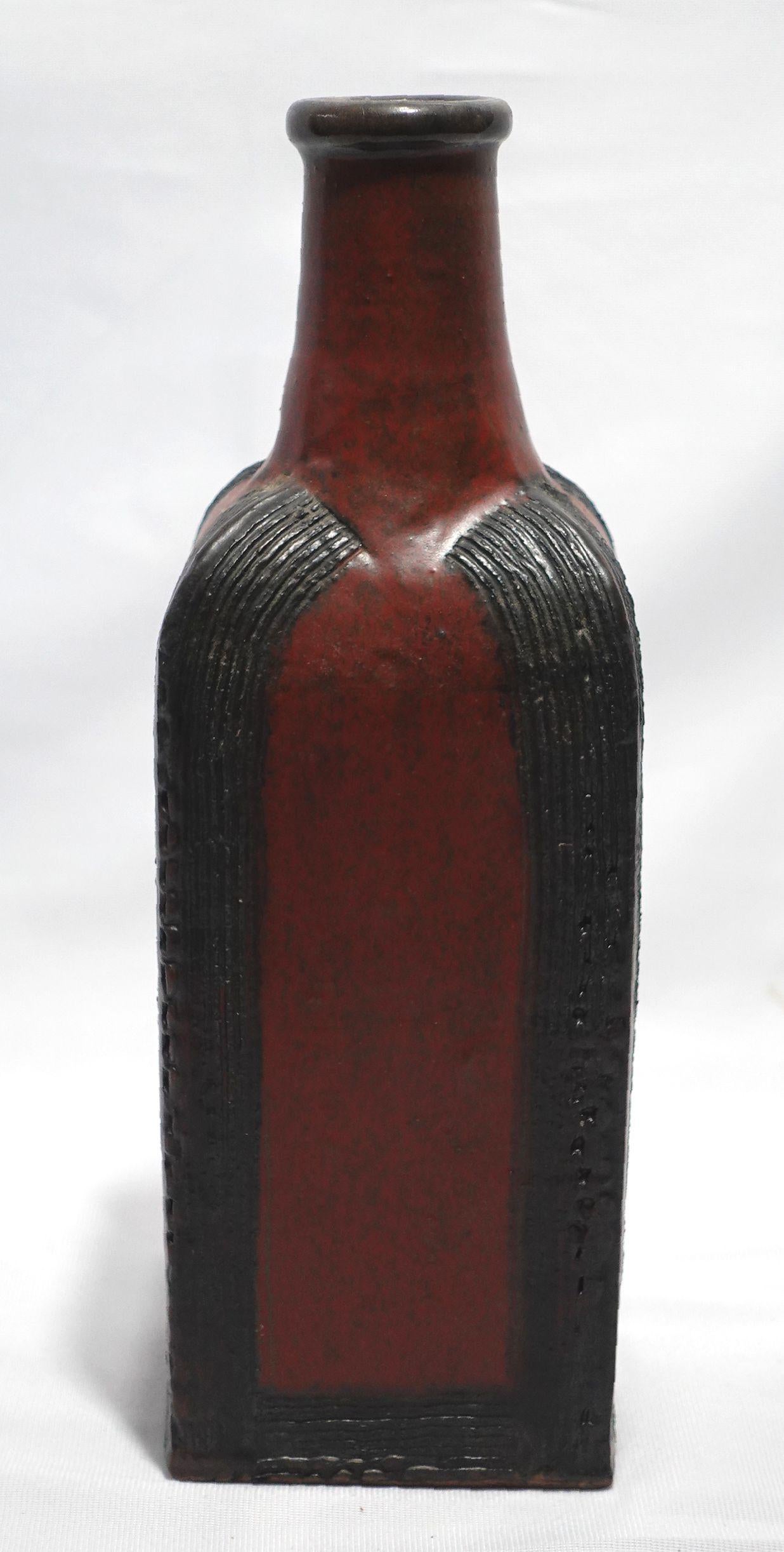 The black and orange squared bottle-shaped vase stands 11.25