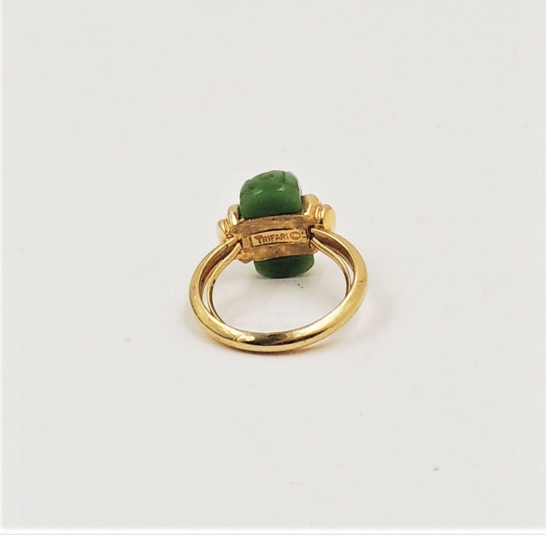 Goldtone carved resin faux-jade ring with inside sizer. Marked 