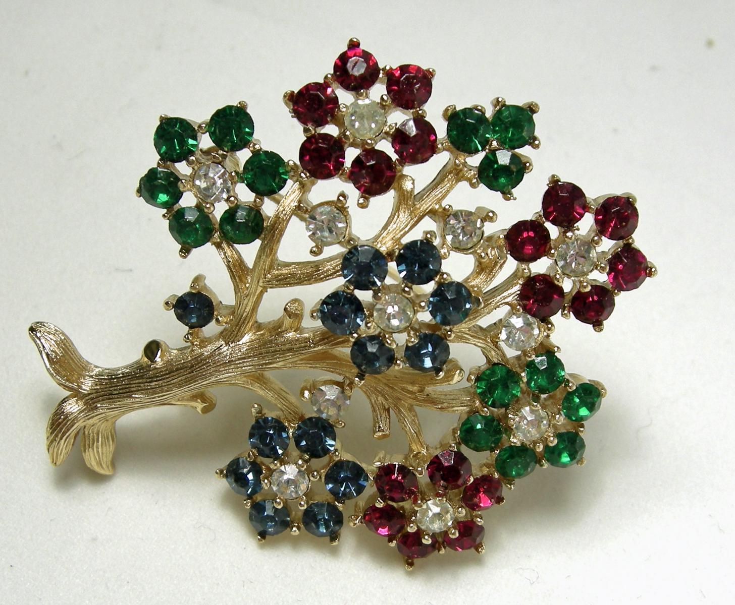 This is the famous Trifari “Tree of Life” brooch with red, green, blue and clear crystals in a gold tone setting.  In excellent condition, this brooch measures 2” x 1-7/8” and is signed with the crown “Trifari”.