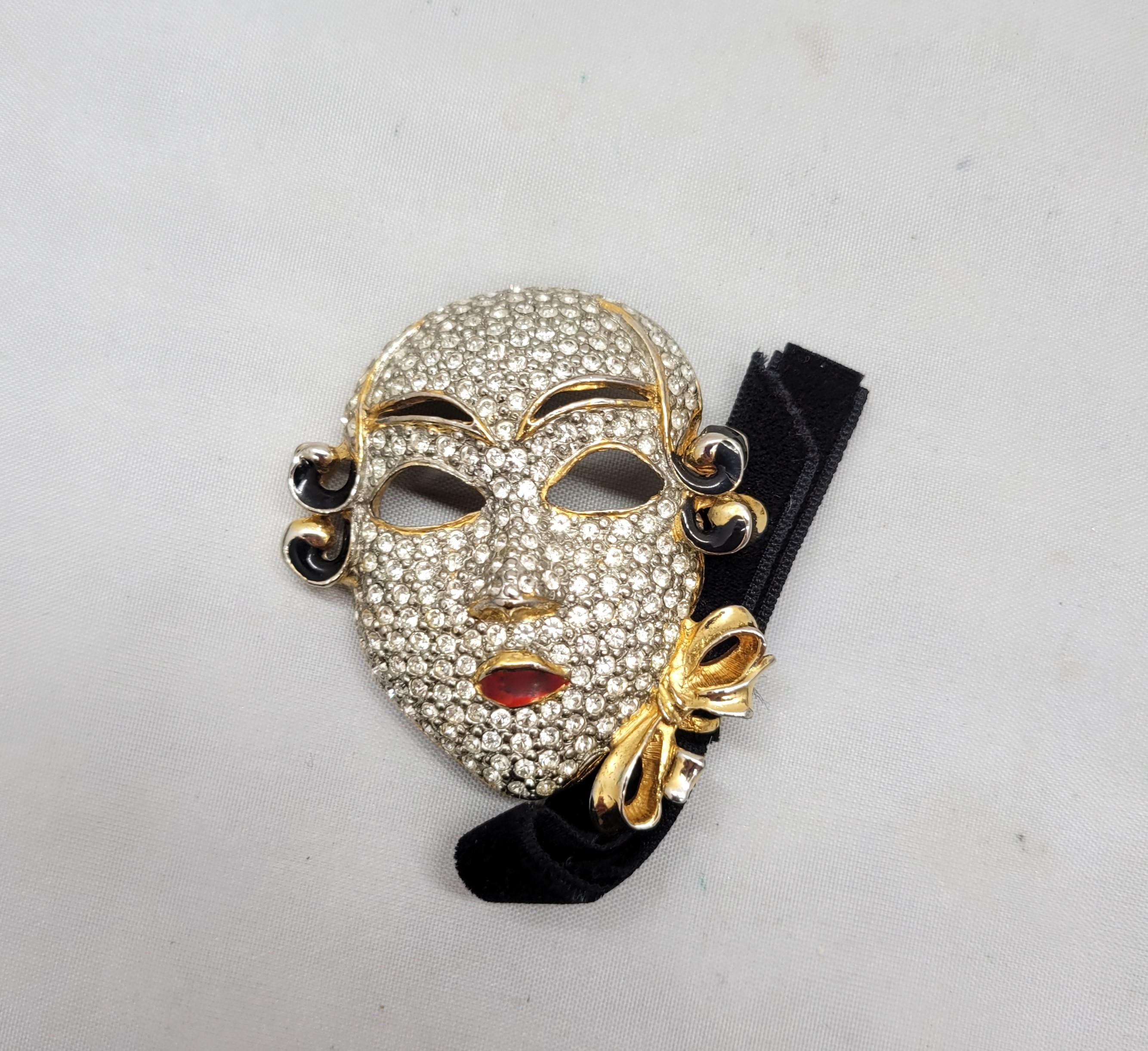 Spilla anni '80 in oro con pave di strass chiari e smalto nero e rosso con fiocco in velluto a maschera veneziana con chiusura di sicurezza. Con la dicitura 
