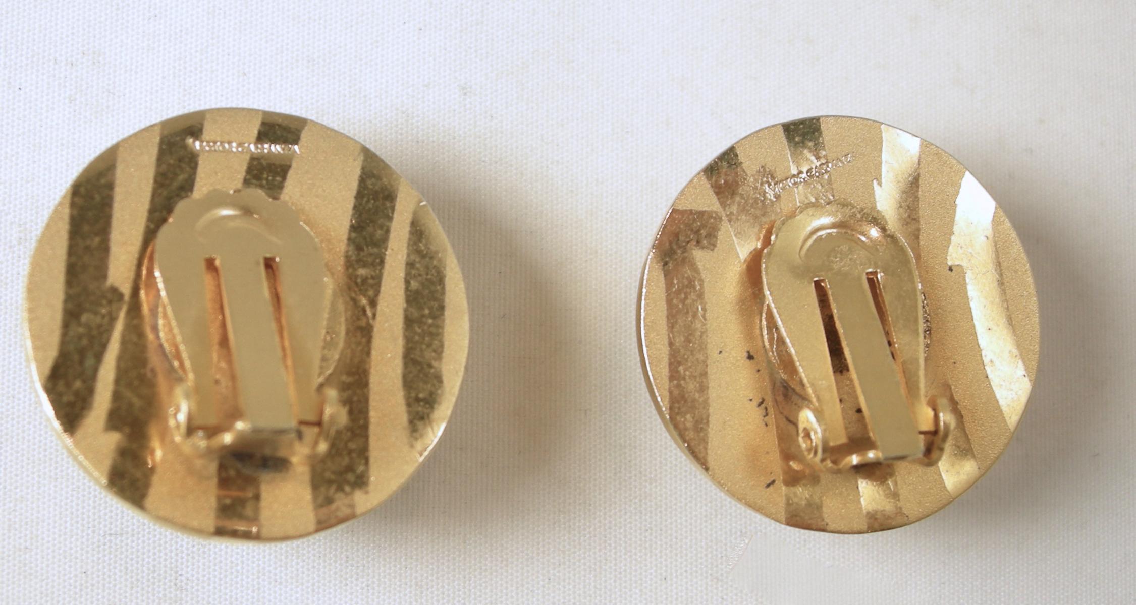 These vintage signed Victor Carranza gold tone earrings have a matte & gloss gold tone stripe ball design. These clip earrings measure 1” across and are signed “Victor Carranza”. They are in excellent condition.