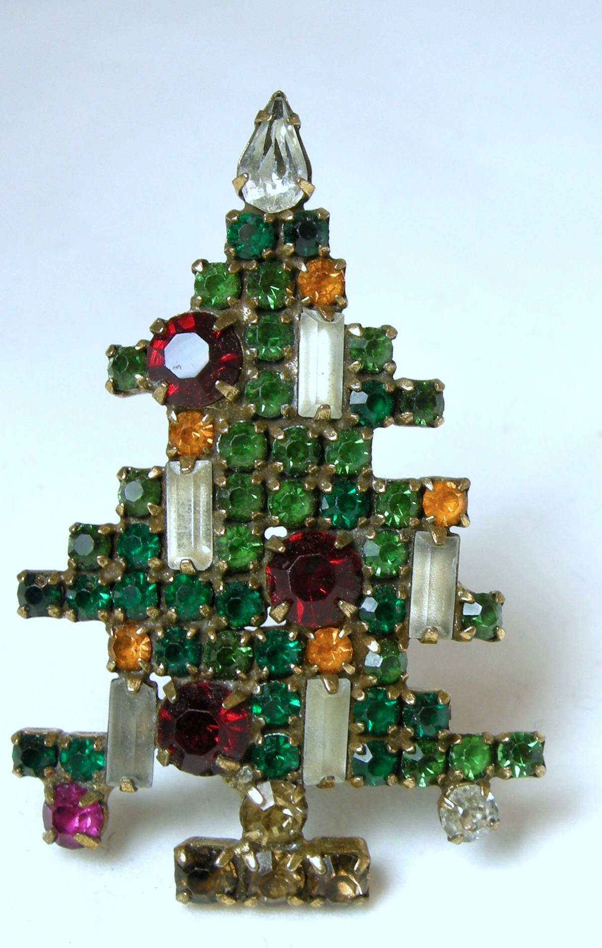 This vintage signed Weiss Christmas tree brooch has 5 candles standing amid multi-colored crystals in a gold tone setting. It is signed “Weiss” and measures 2-1/4” x 1-1/2”.  It’s in excellent condition.
