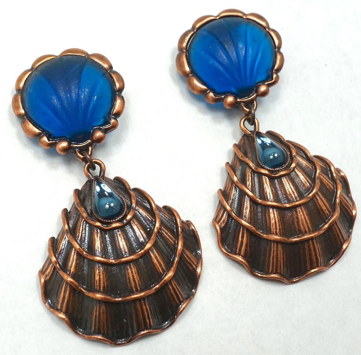 These vintage signed Yves St. Laurent earrings have a shell design with a blue melon seashell top with blue crystals in a copper tone setting.  In excellent condition, these clip earrings measure 3-1/4” x 1-3/4” and are signed “Yves St. Laurent,