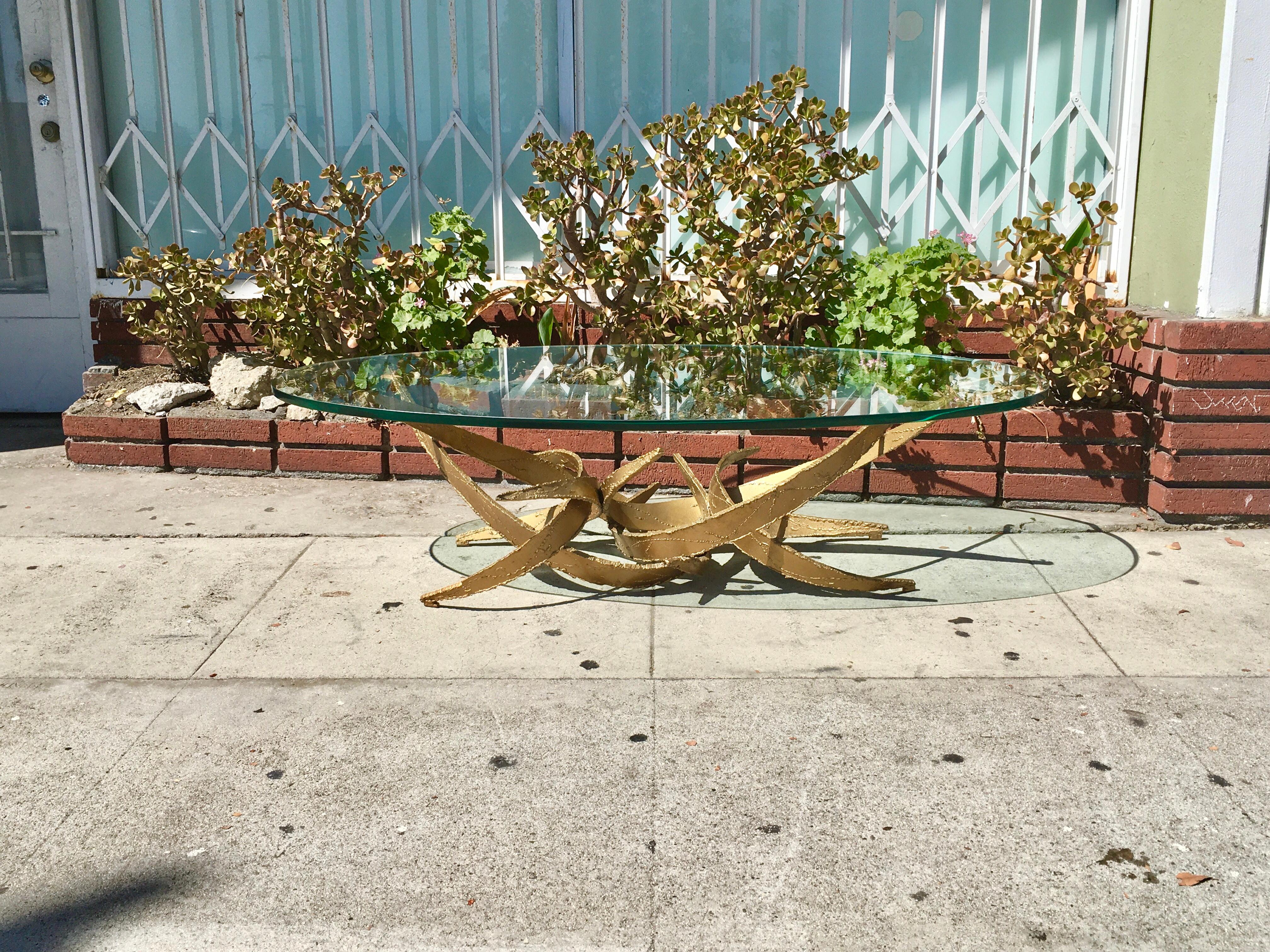 This stunning sculptural brutalist coffee table was designed and manufactured by Silas Seandel in the united states circa 1960s. This fantastic coffee table features a curved gold-tone torch-cut metal formed into an organically abstract structure