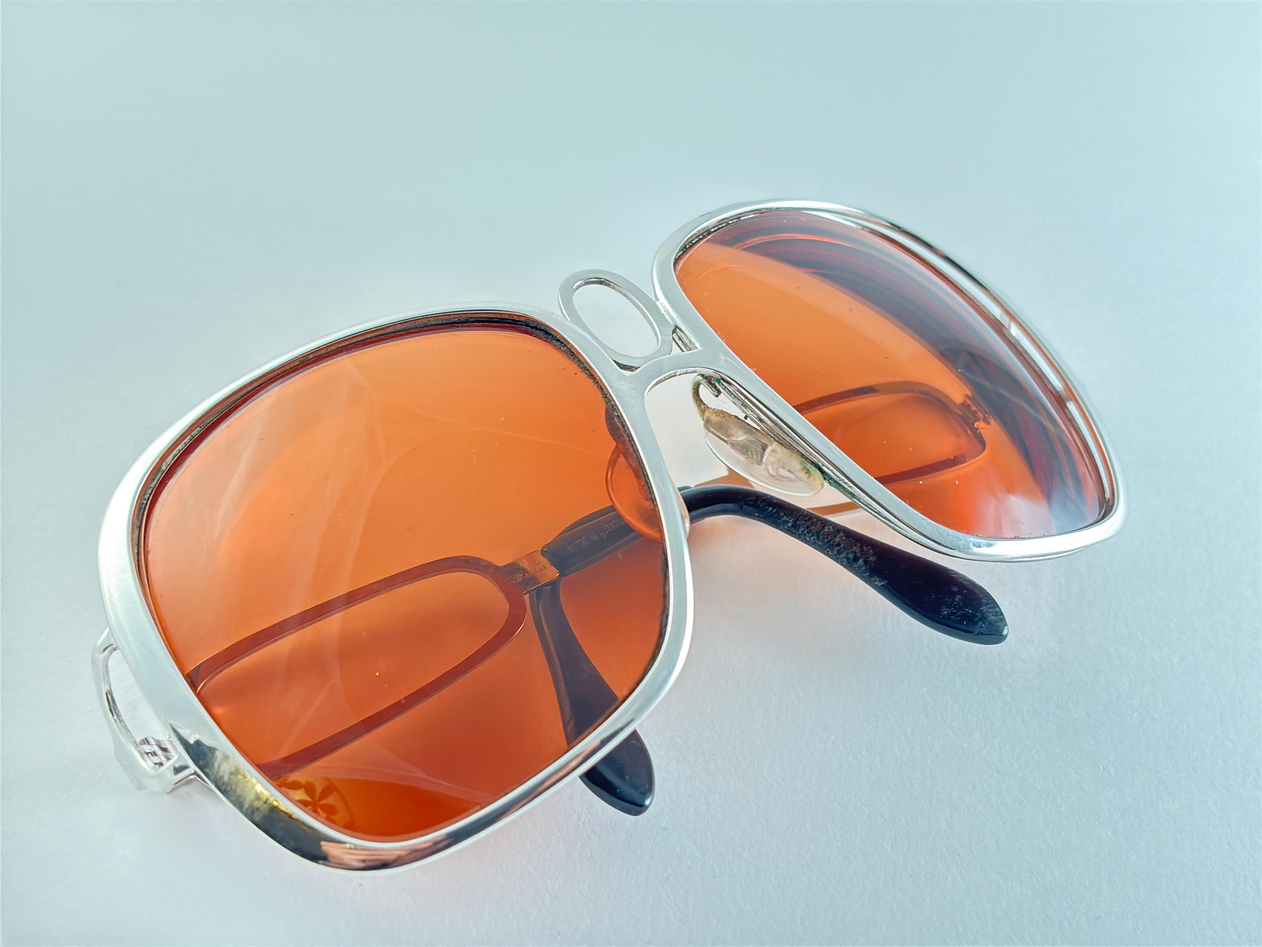 
Gafas de sol de silueta funky y Uber Cool. Montura Plateada De Gran Tamaño Que Sujeta Un Par De Lentes Ámbar.
La montura y los cristales presentan un ligero desgaste debido a 40 años de almacenamiento.
Excelente calidad,  Un diseño aún