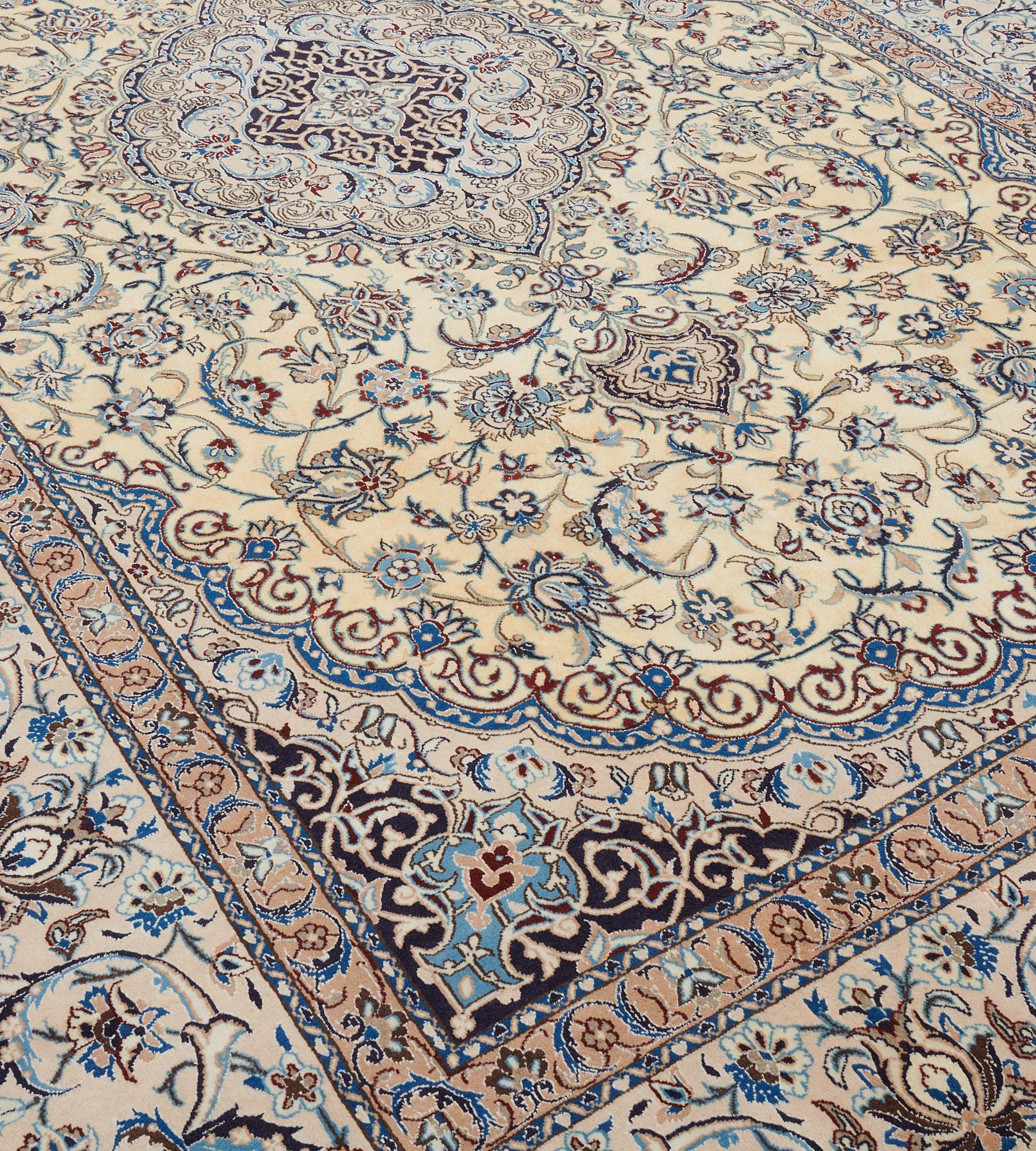This vintage silk and wool Persian Nain rug has a pale sandy-yellow field with a central buff-brown cusped medallion with palmette pendants containing a central charcoal-blue medallion with scrolling arabesque vine around a cusped lozenge medallion,