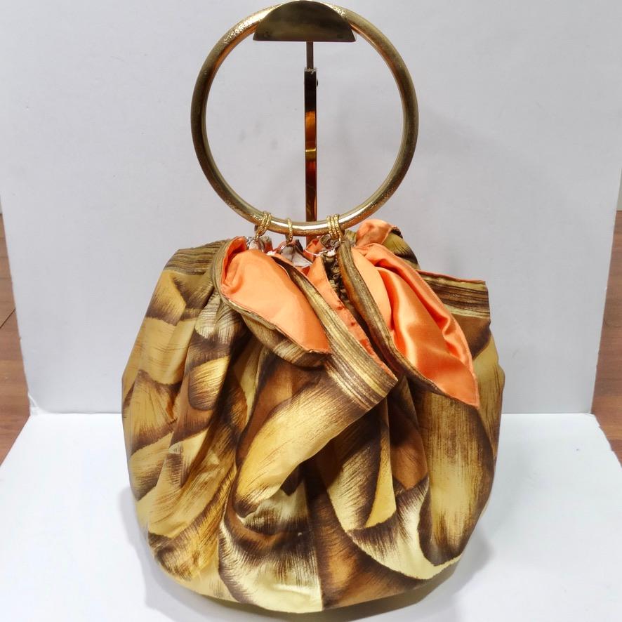 Do not miss out on this unique furoshiki style handbag made out of a silk scarf! The most beautiful warm brown printed silk and brushed gold plated circular handle are joined together by gold O-rings to create this super fun synched handbag! This is
