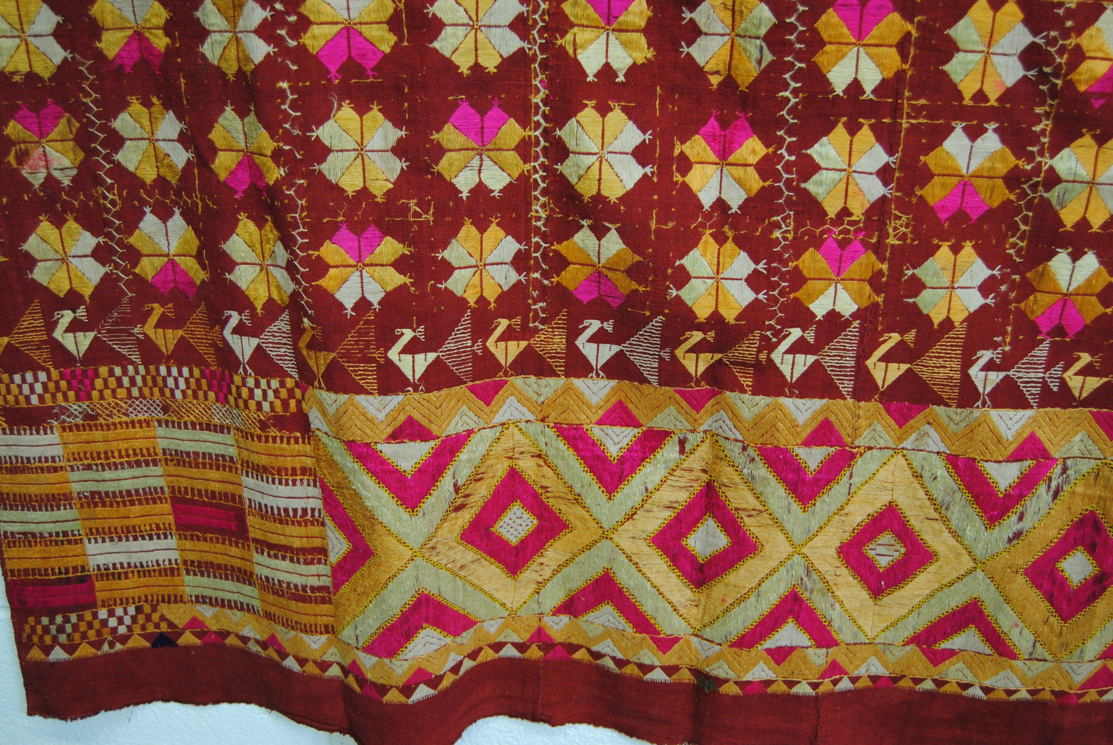 Vintage silk embroidered wedding shawl from Punjab, India. The base cloth is handwoven cotton khadi cloth that is hand embroidered with vibrant silk threads. It was traditionally made by members of the young bride's family for her wedding and other