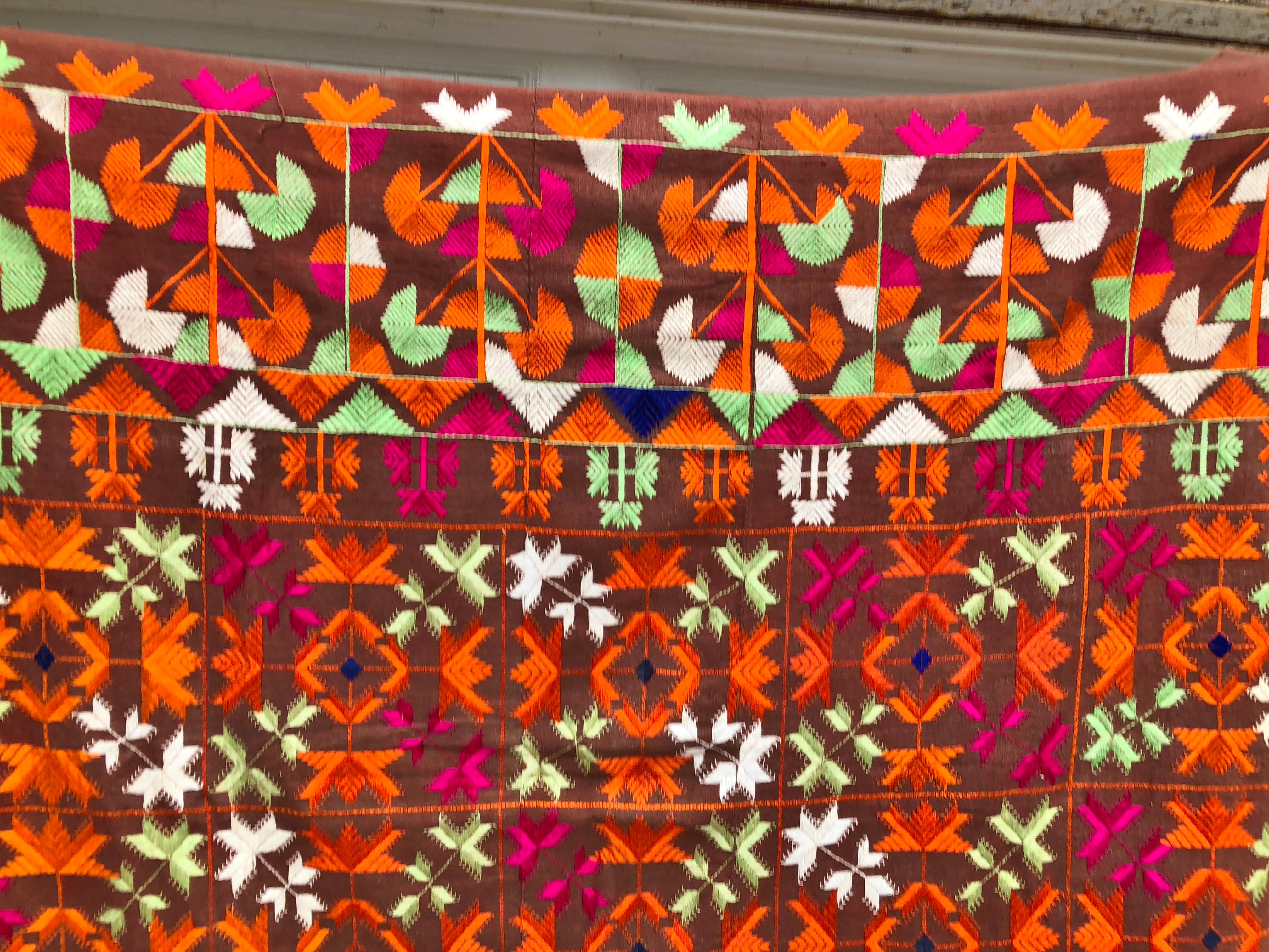 Vintage silk embroidered Phulkari wedding shawl from Punjab, India. The textile is handwoven cotton khadi cloth that is hand embroidered with vibrant silk threads by relatives of the young bride for her wedding and other special occasions. The shawl